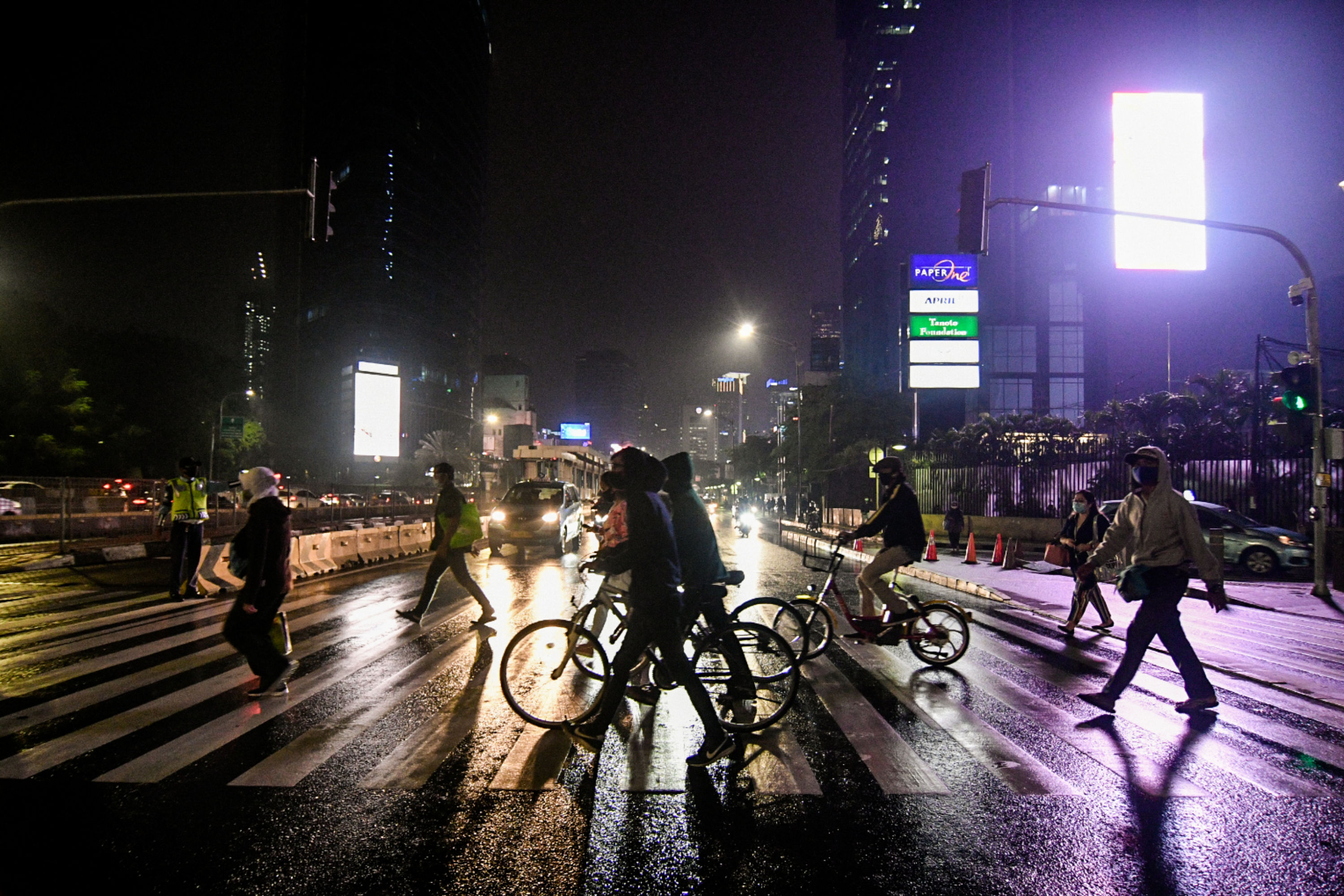 Pekerja menyeberangi Pelican Crossing di kawasan Sudirman, Jakarta, saat pemberlakuan PSBB transisi.