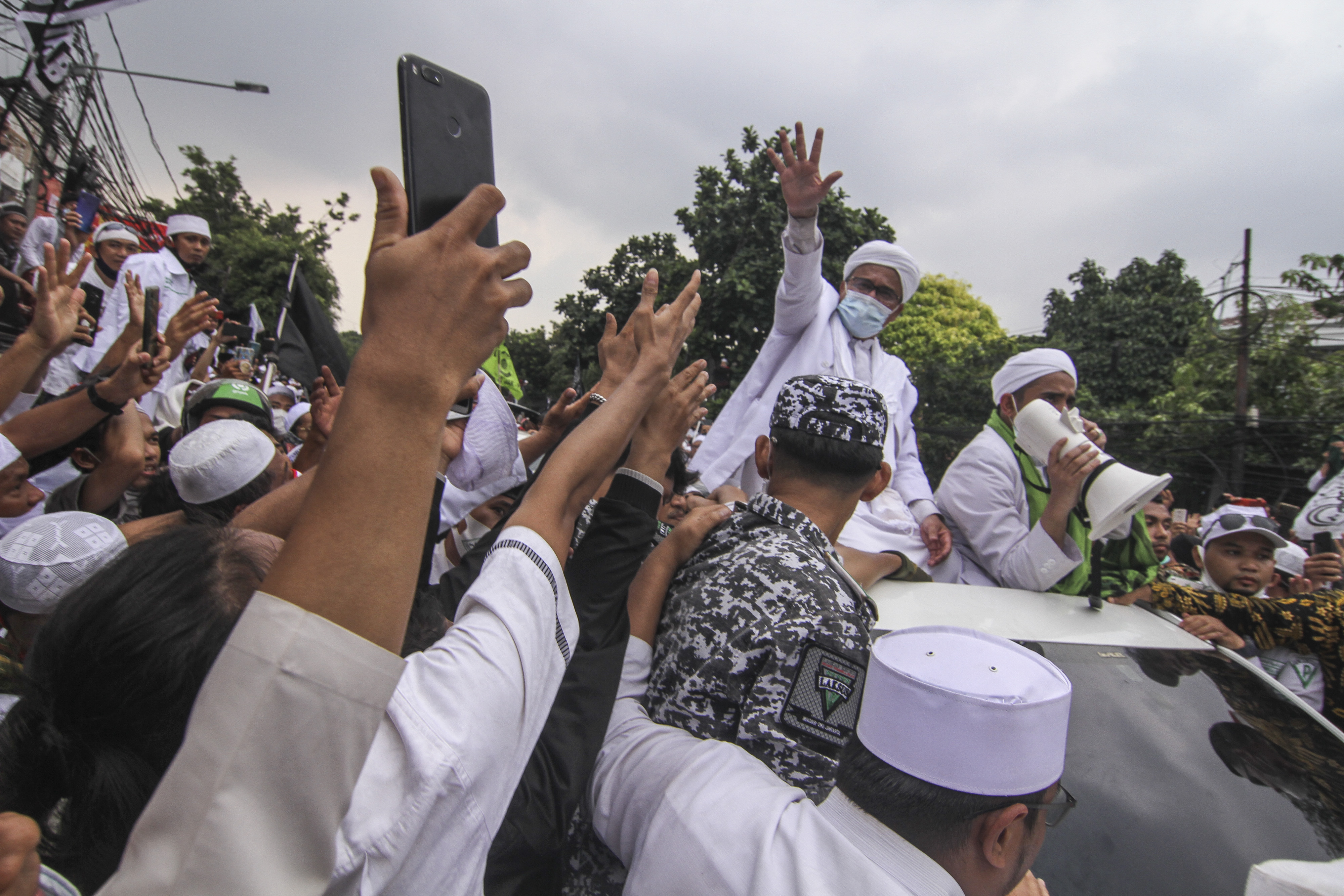 Imam Besar FPI Rizieq Shihab (kedua dari kanan) menyapa massa yang menyambutnya di Petamburan, Jakarta.