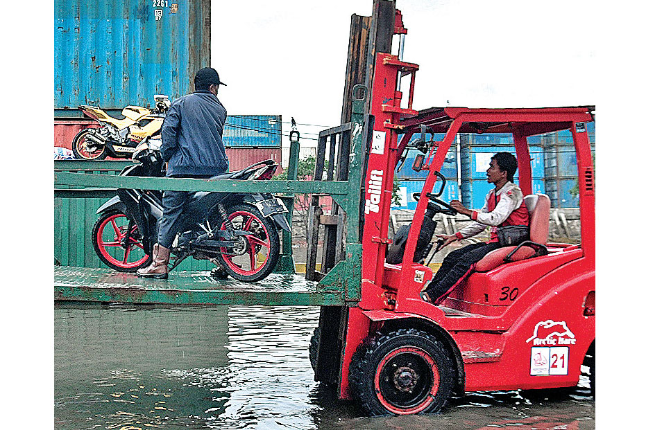 BANJIR ROB: Pengendara sepeda motor menumpang alat berat untuk menghindari banjir rob yang menggenangi kawasan Pelabuhan Sunda Kelapa,  r