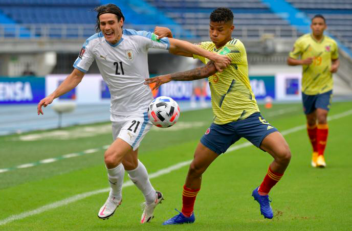 Uruguay Edinson Cavani (kiri) berebut bola dengan pemain Kolombia Wilmar Barrios (kanan)