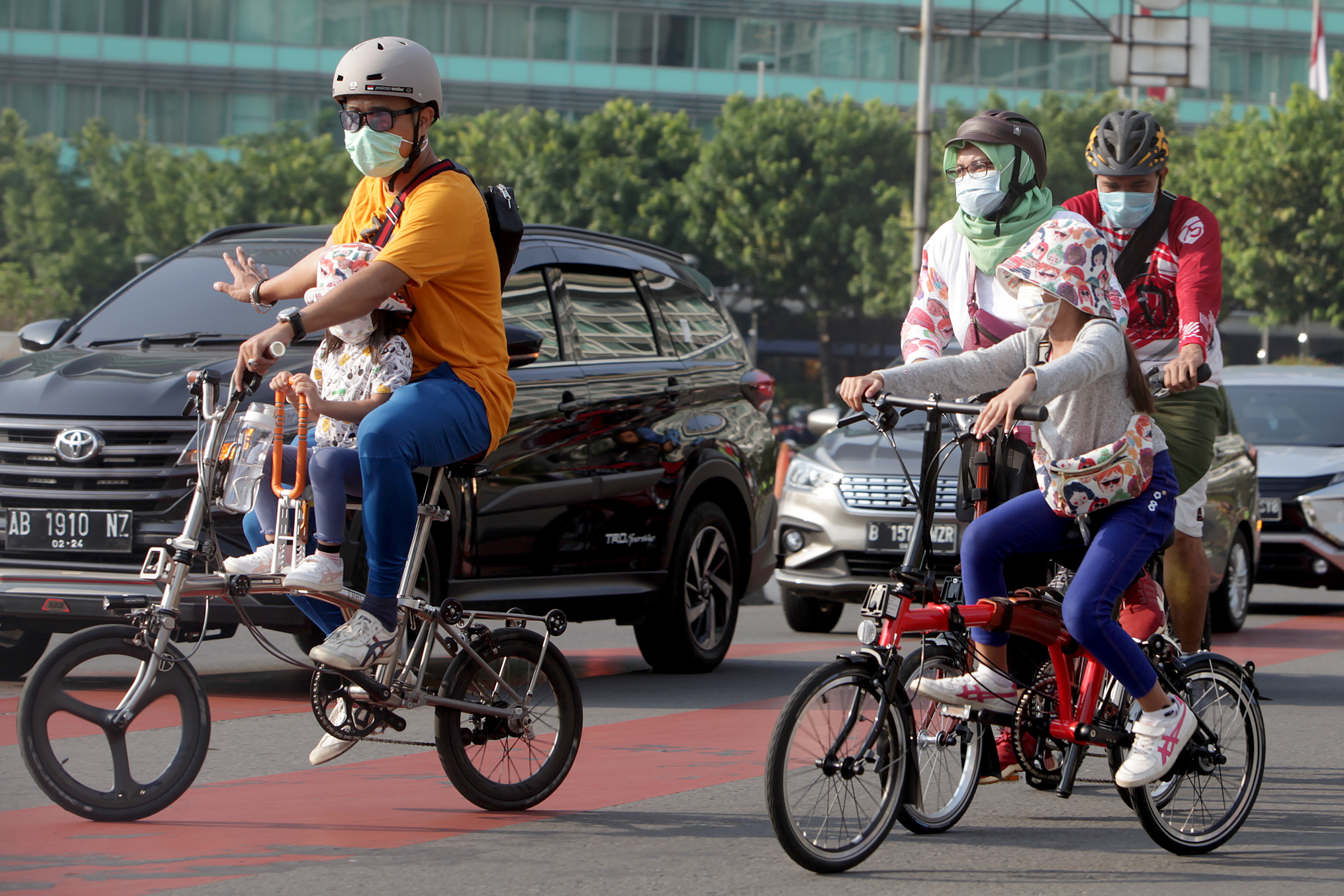 Warga bersepeda dengan mengenakan masker melintasi Bundaran HI Jakarta, Minggu (8/11/2020)