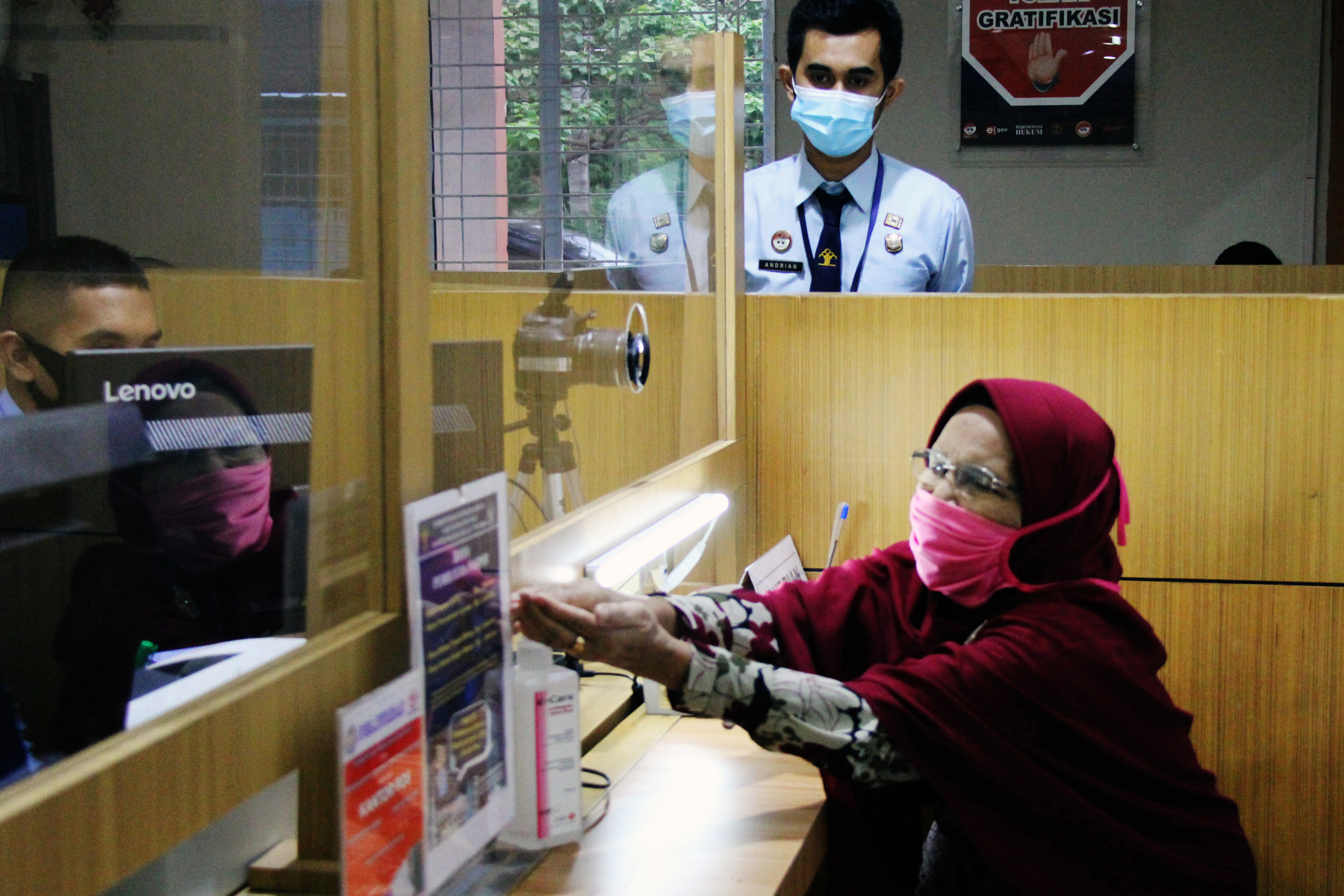 Calon jemaah umrah membersihkan tangan sebelum cap sidik jari untuk mengurus paspor di Kantor Imigrasi Kelas II TPI Dumai, Riau, Rabu (4/11)