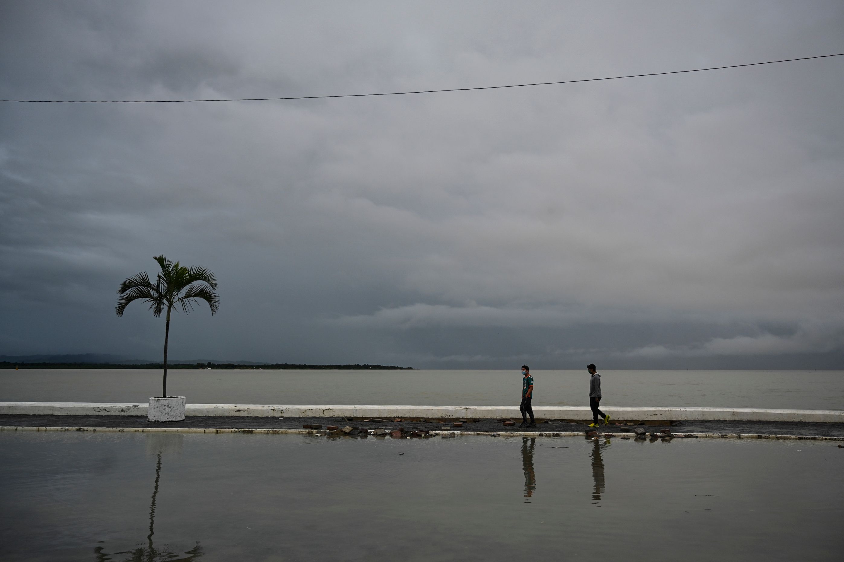 Warga melintasi jalan di wilayah Puerto Barrios, Guatemala, yang terendam banjir akibat Badai Eta.