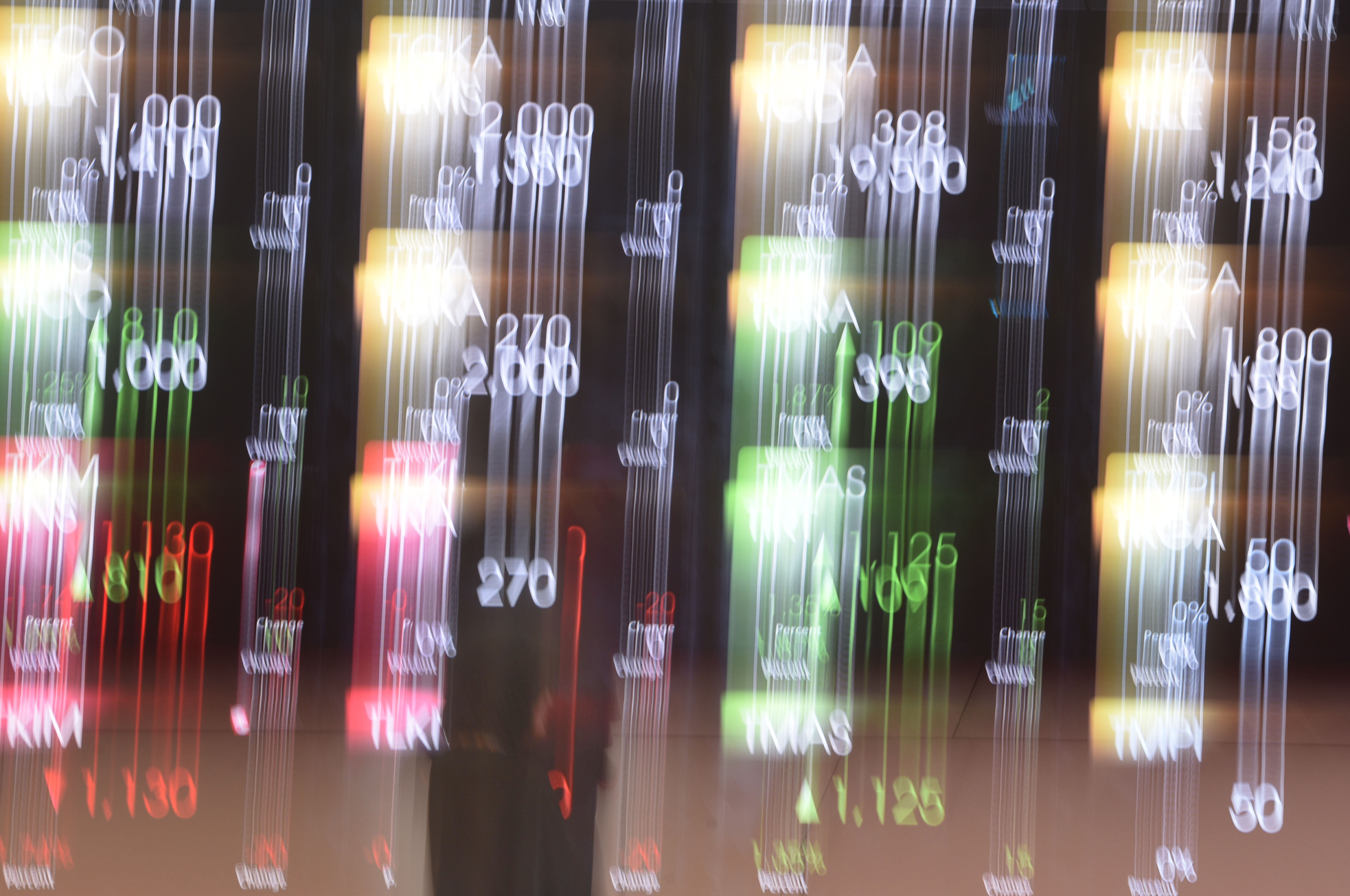 Seorang wanita memerhatikan layar elektronik pergerakan saham di Bursa Efek Indonesia, Jakarta, Jumat (4/8).