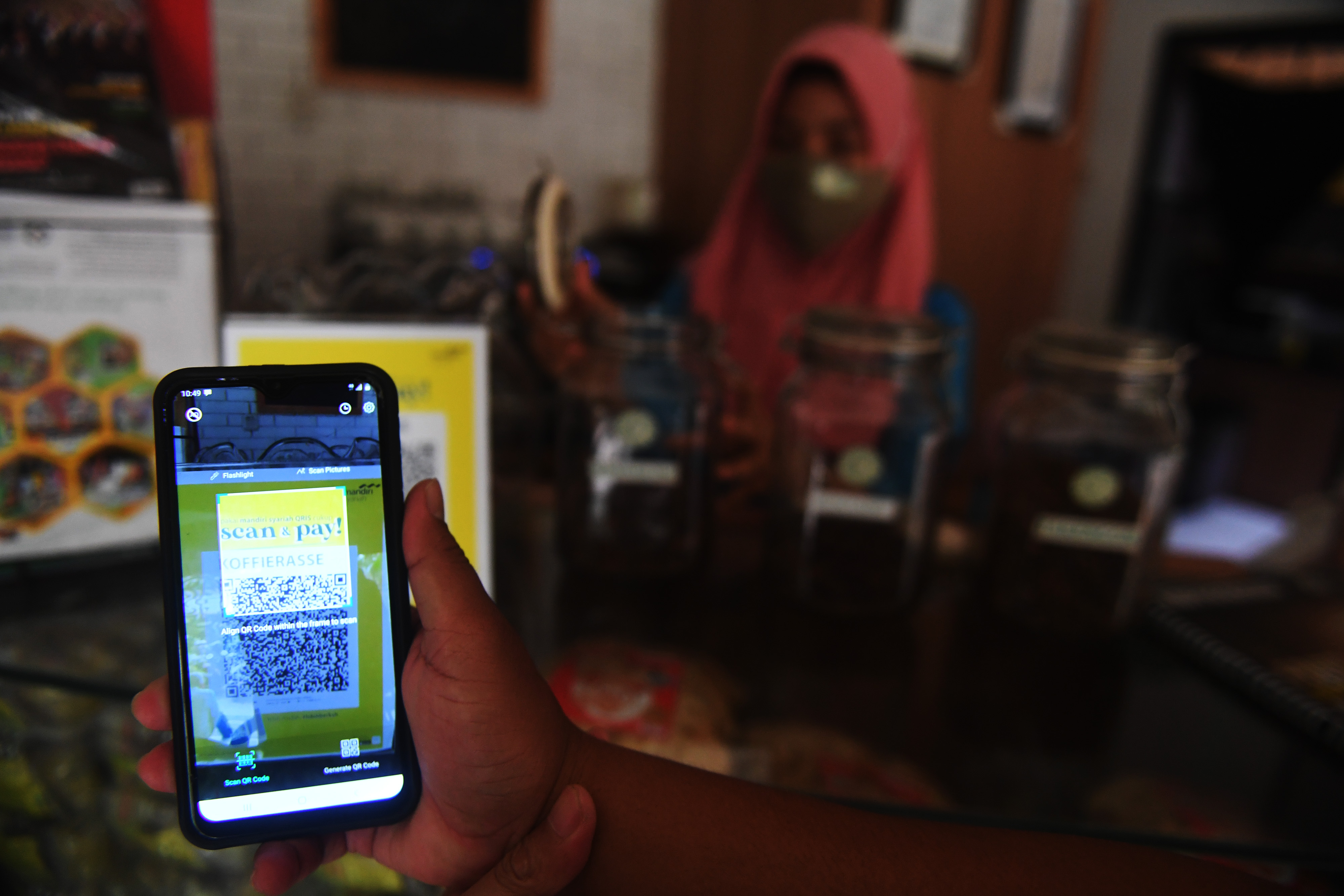 Seorang warga melakukan pembayaran digital lewat QRIS.