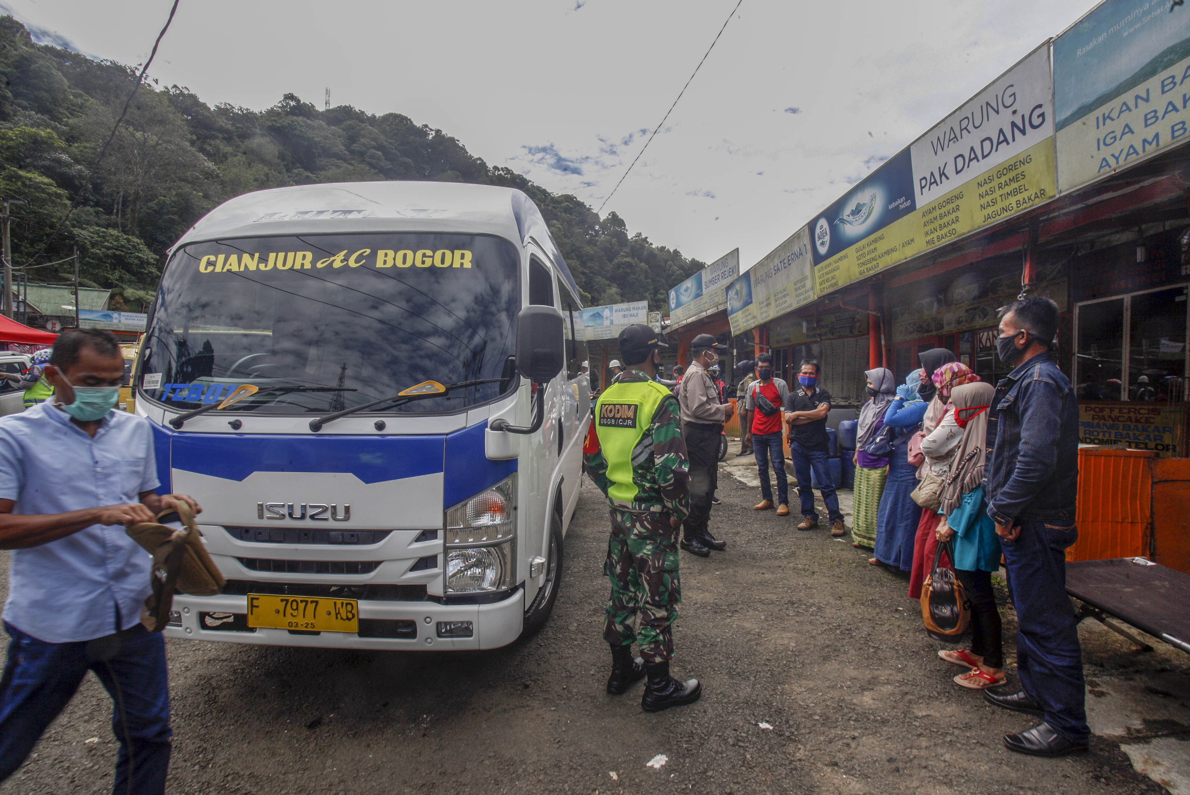 Petugas gabungan memberikan imbauan kepada warga di titik pemeriksaan perbatasan Cianjur-Bogor.