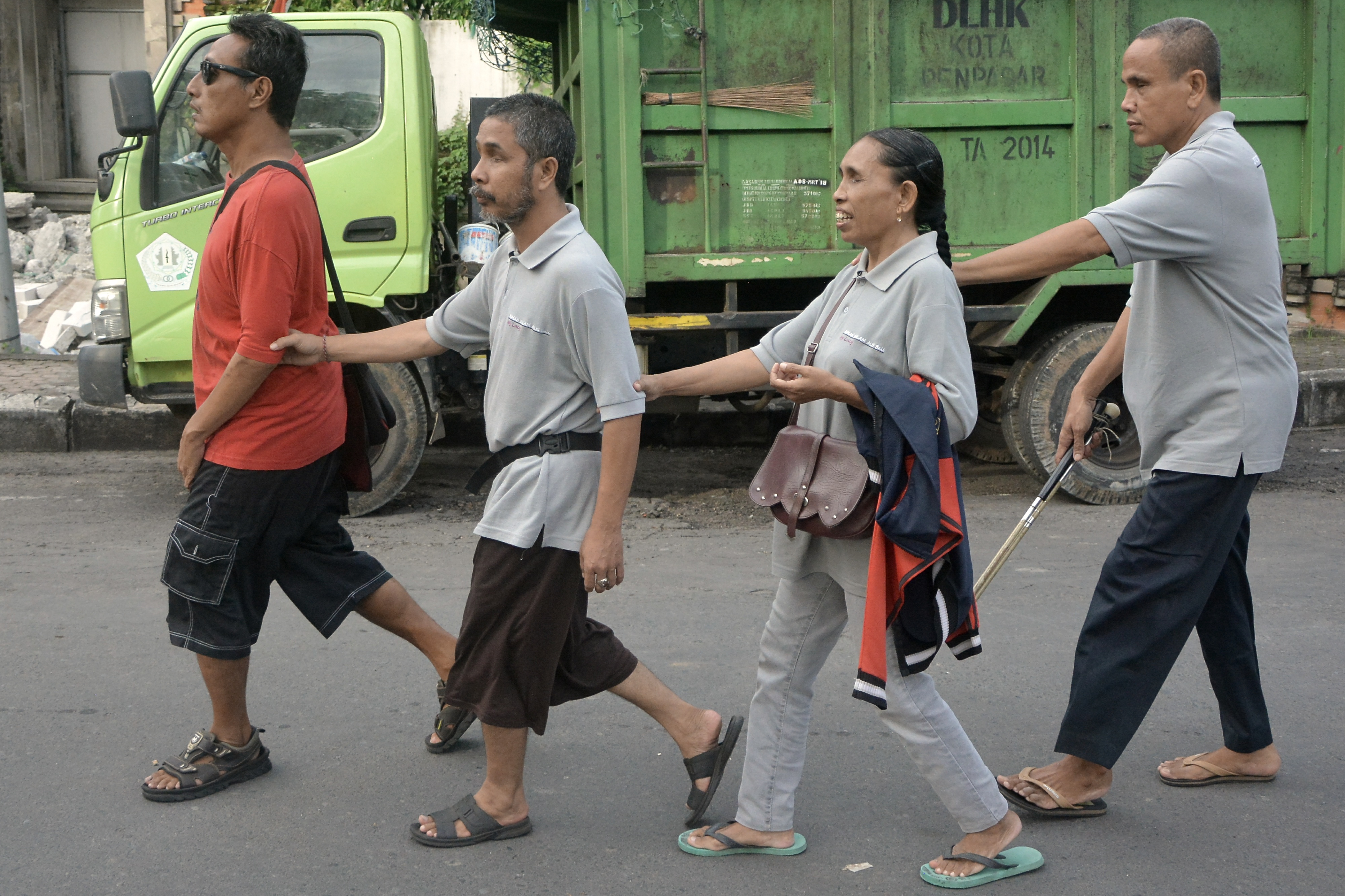 Sejumlah penyandang tuna netra bergandengan saat mengikuti kegiatan jalan sehat di kawasan Lumintang, Denpasar, Bali.