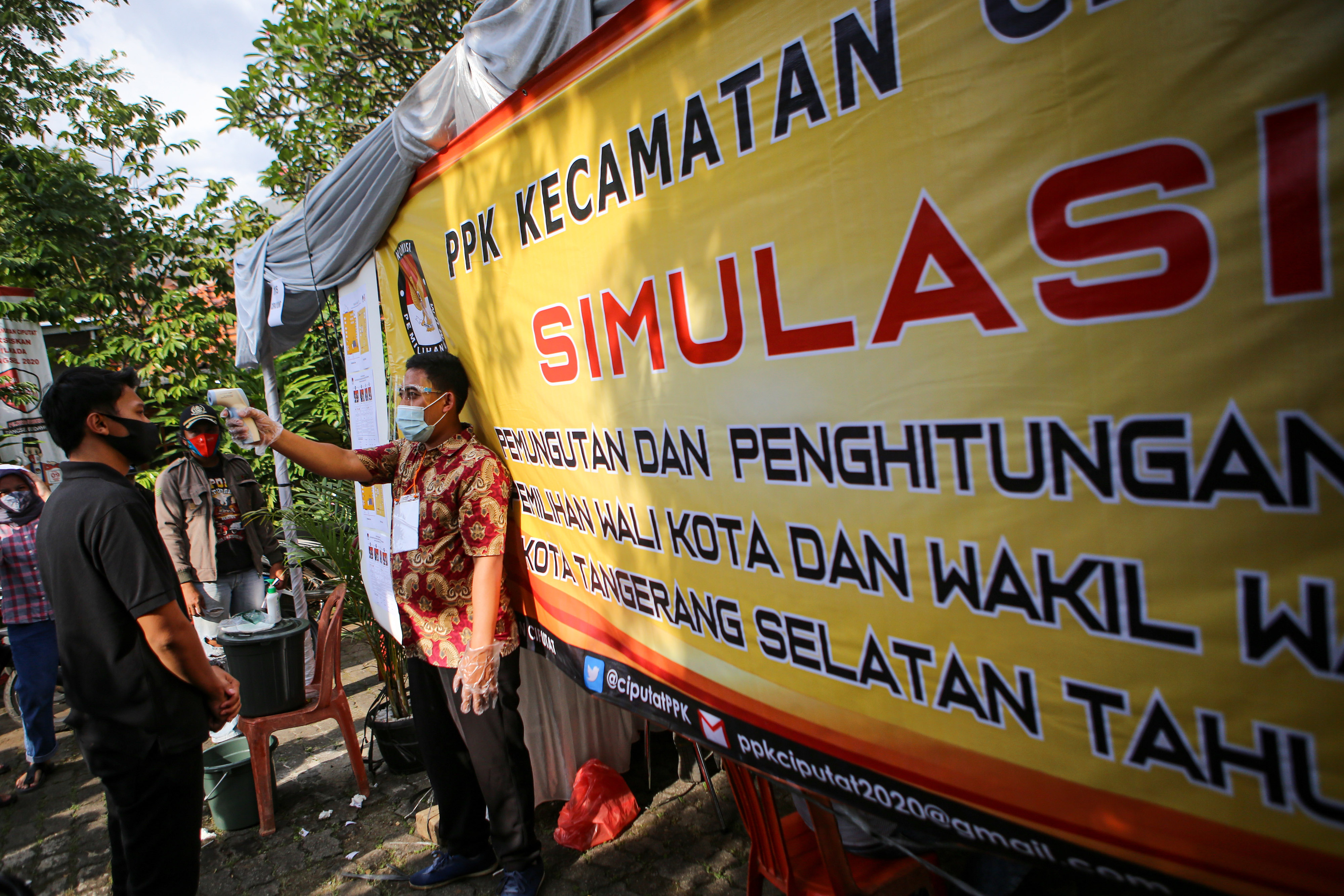 Petugas PPK Ciputat memeriksa suhu tubuh warga sebelum memasuki TPS saat simulasi di Ciputat, Kota Tangerang Selatan, Banten, Kamis (26/11)