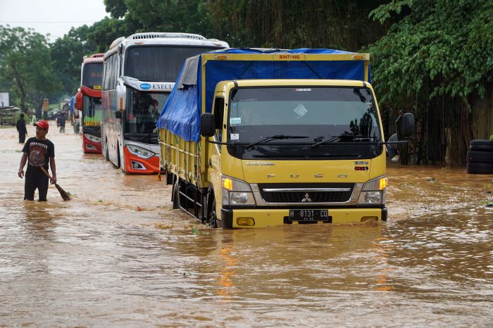 Sejumlah kendaraan melintas di jalan nasional, tepatnya ruas jalan Sumpiuh, Banyumas, Jawa Tengah (Jateng) yang dilanda banjir. 