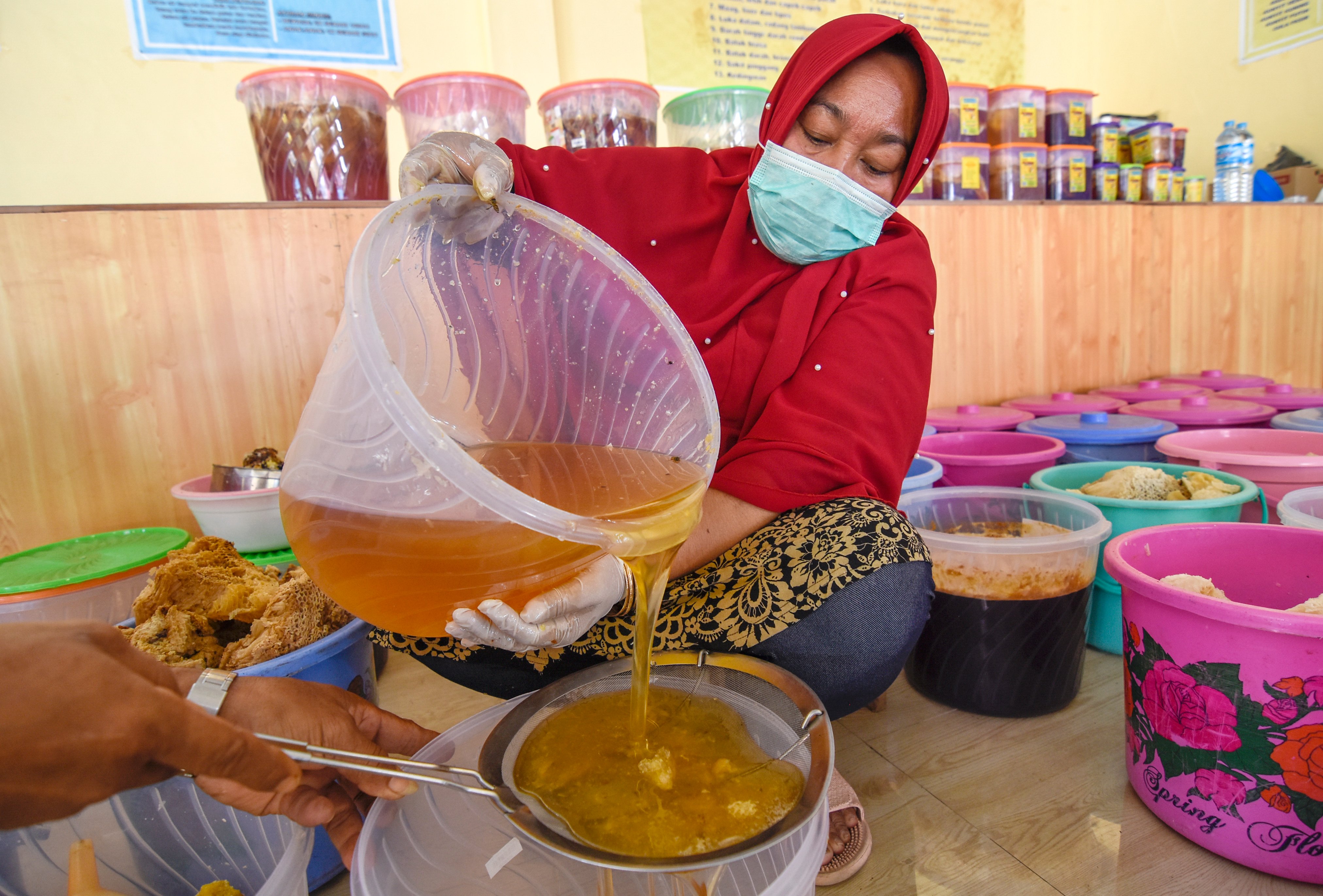  Seorang perempuan menyaring madu hutan Sumbawa di UMKM Madu Lestari Sumbawa di Desa Semongkat, NTB. Madu ini juga diekspor ke luar negeri.
