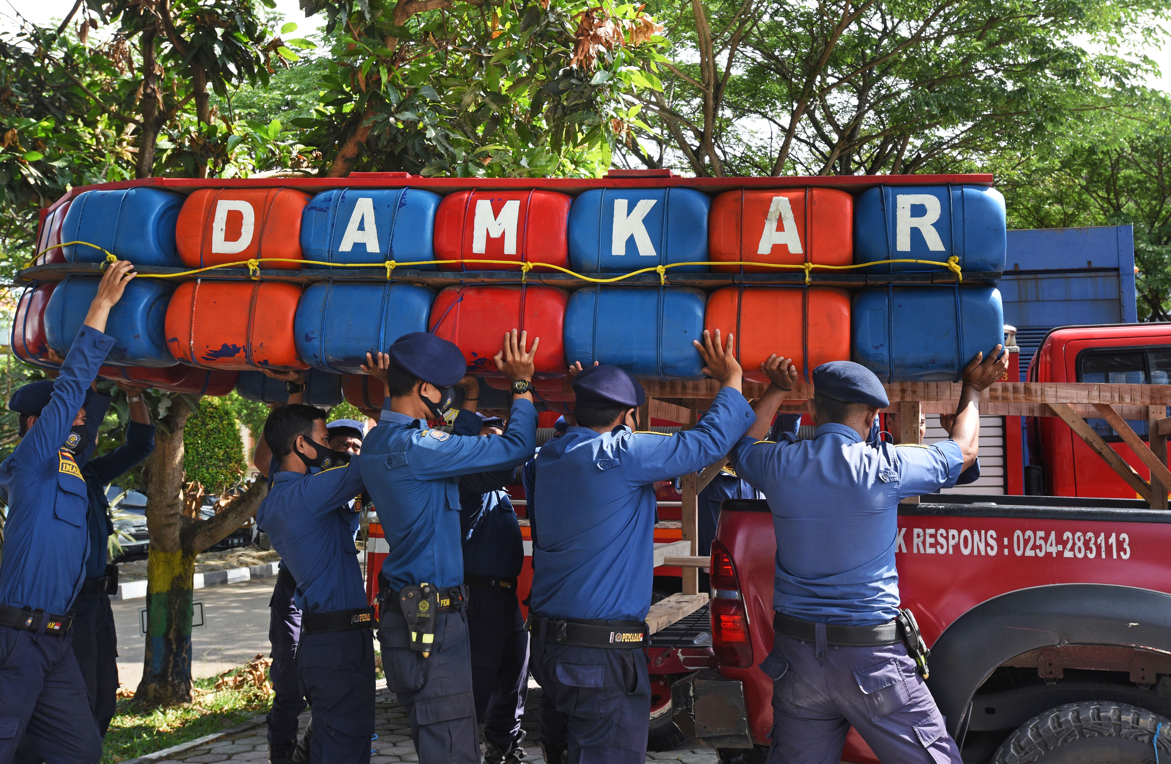 IAGA BENCANA JELANG MUSIM HUJAN: Sejumlah personel pemadam kebaran menggotong sekoci penyelematan korban bencana saat Apel Siaga Bencana  