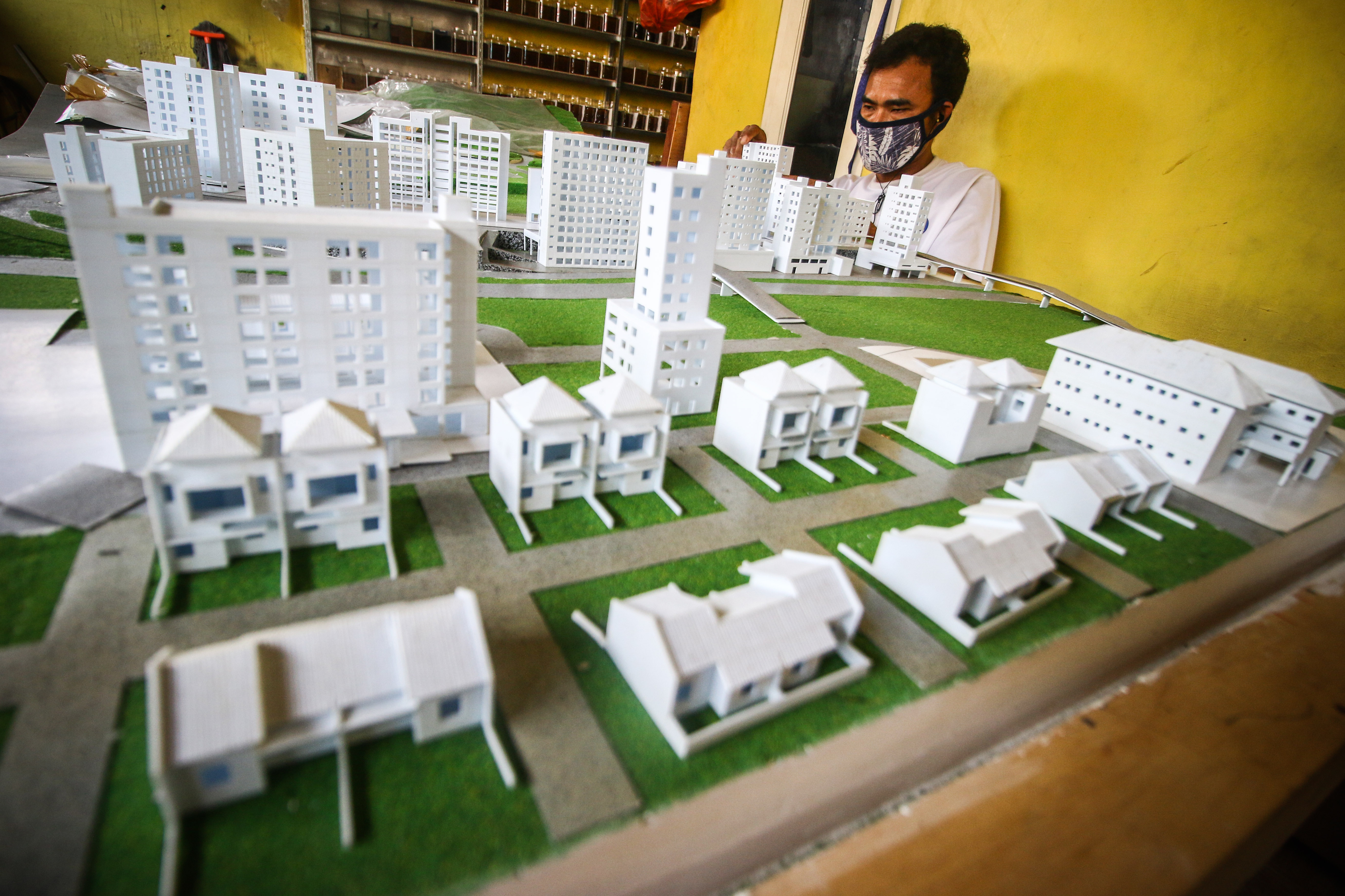 Pekerja menyelesaikan pembuatan maket gedung di Joglo, Jakarta.