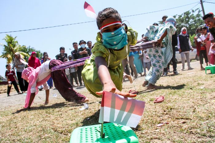 Ilustrasi . Anak pengungsi etnis Rohingya berusaha meraih bendera saat berlomba tarik sarung di tempat penampungan Balai Latihan Kerja (BLK)