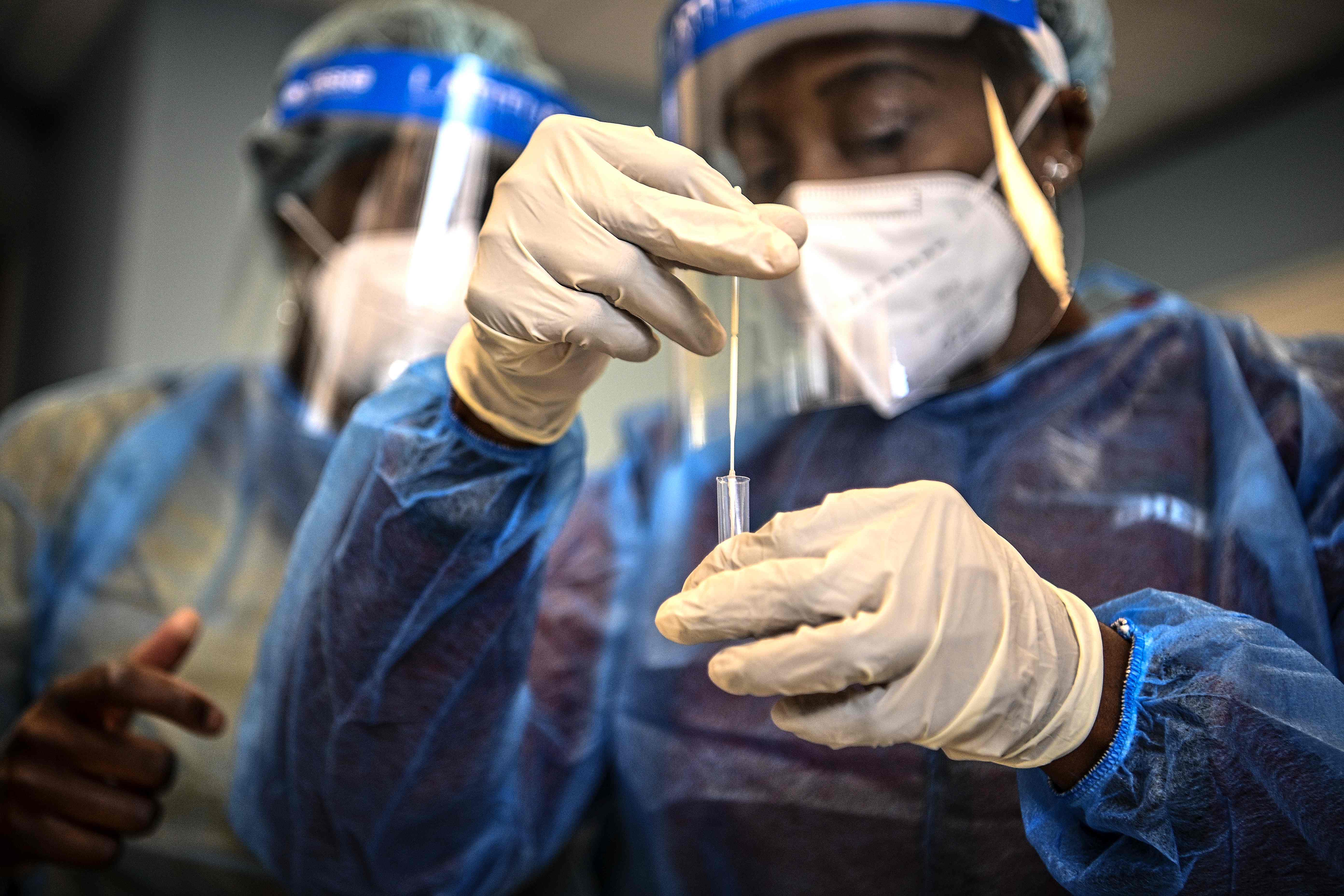 Ilustrasi: Petugas medis memasukan lendir dari tes usap