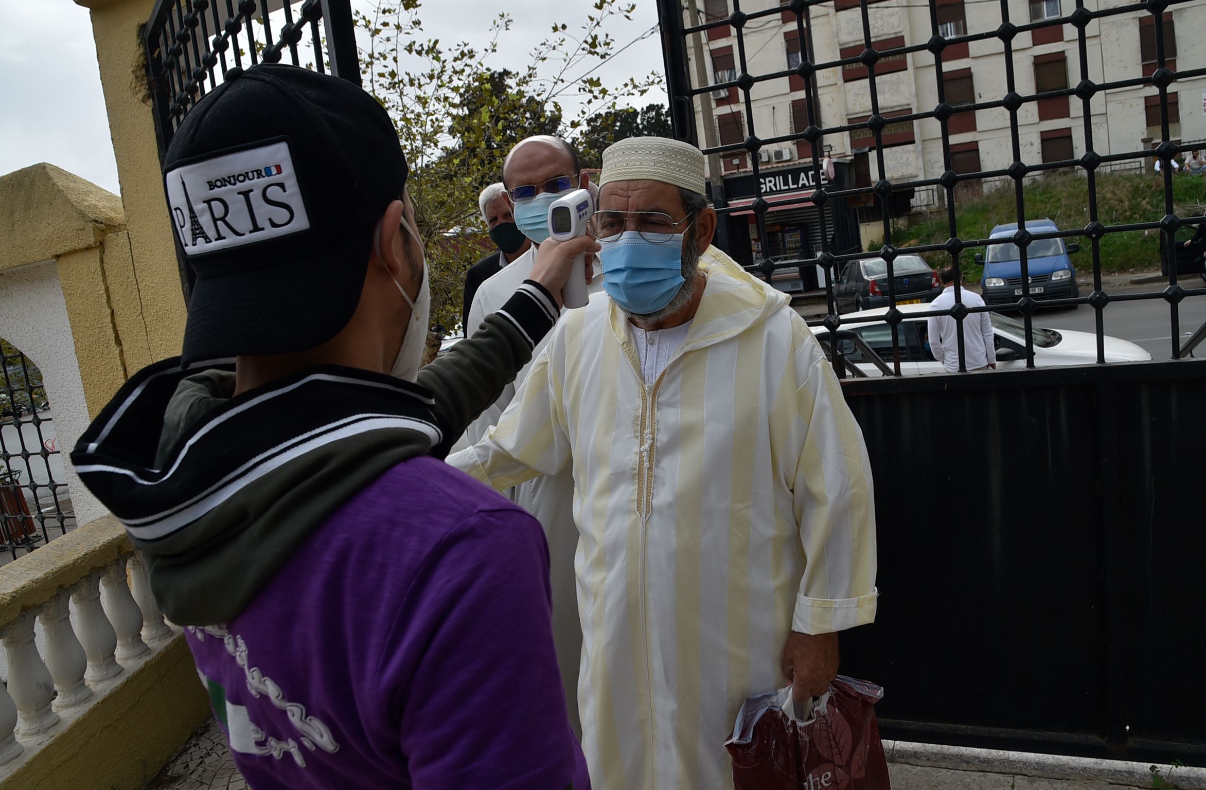 Warga yang akan melakukan salat Jumat di Algiers, Aljazair diperiksa suhu tubuhnya.