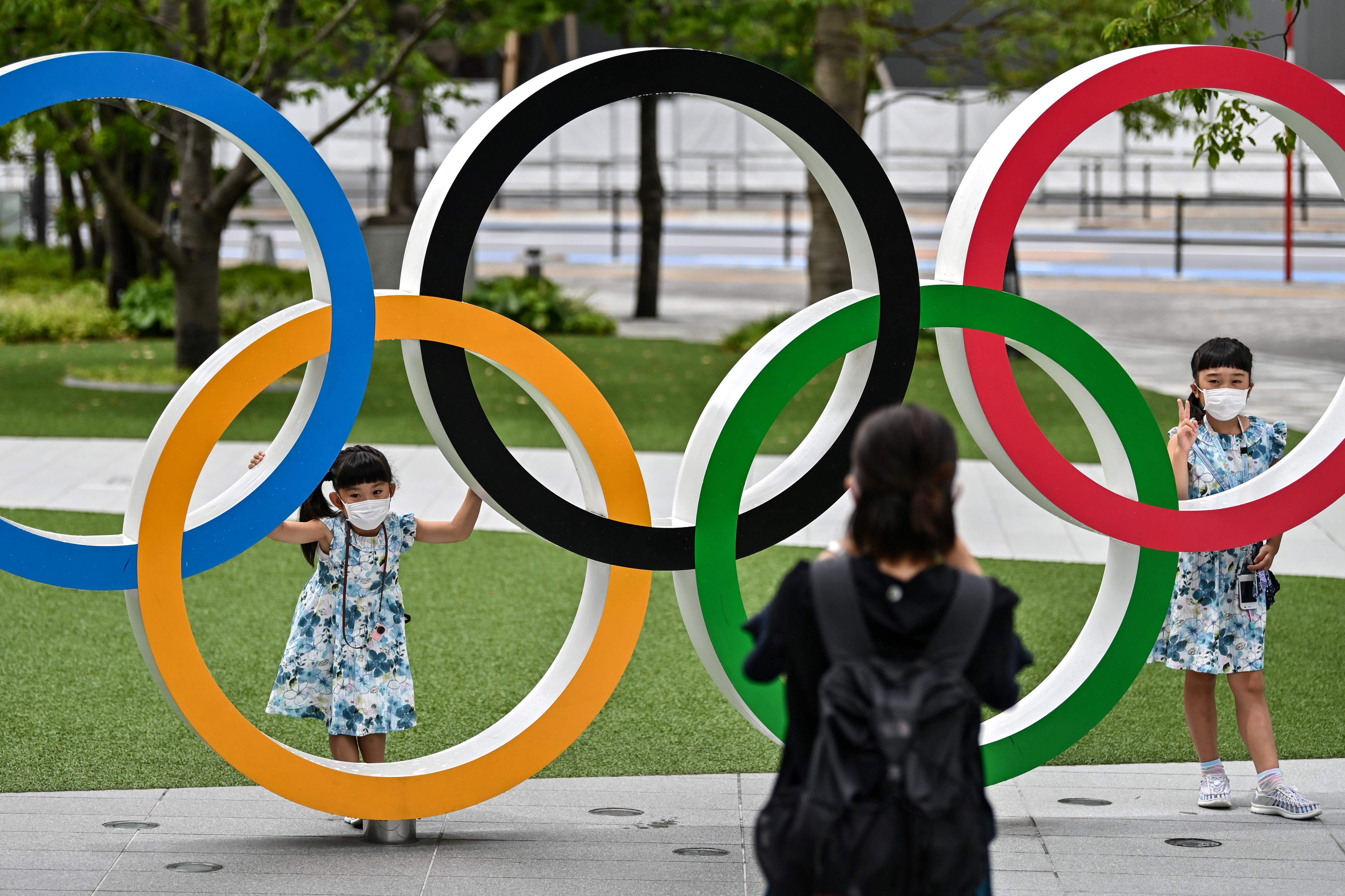 Dua anak perempuan berpose di simbol Olimpiade Tokyo, Jepang.