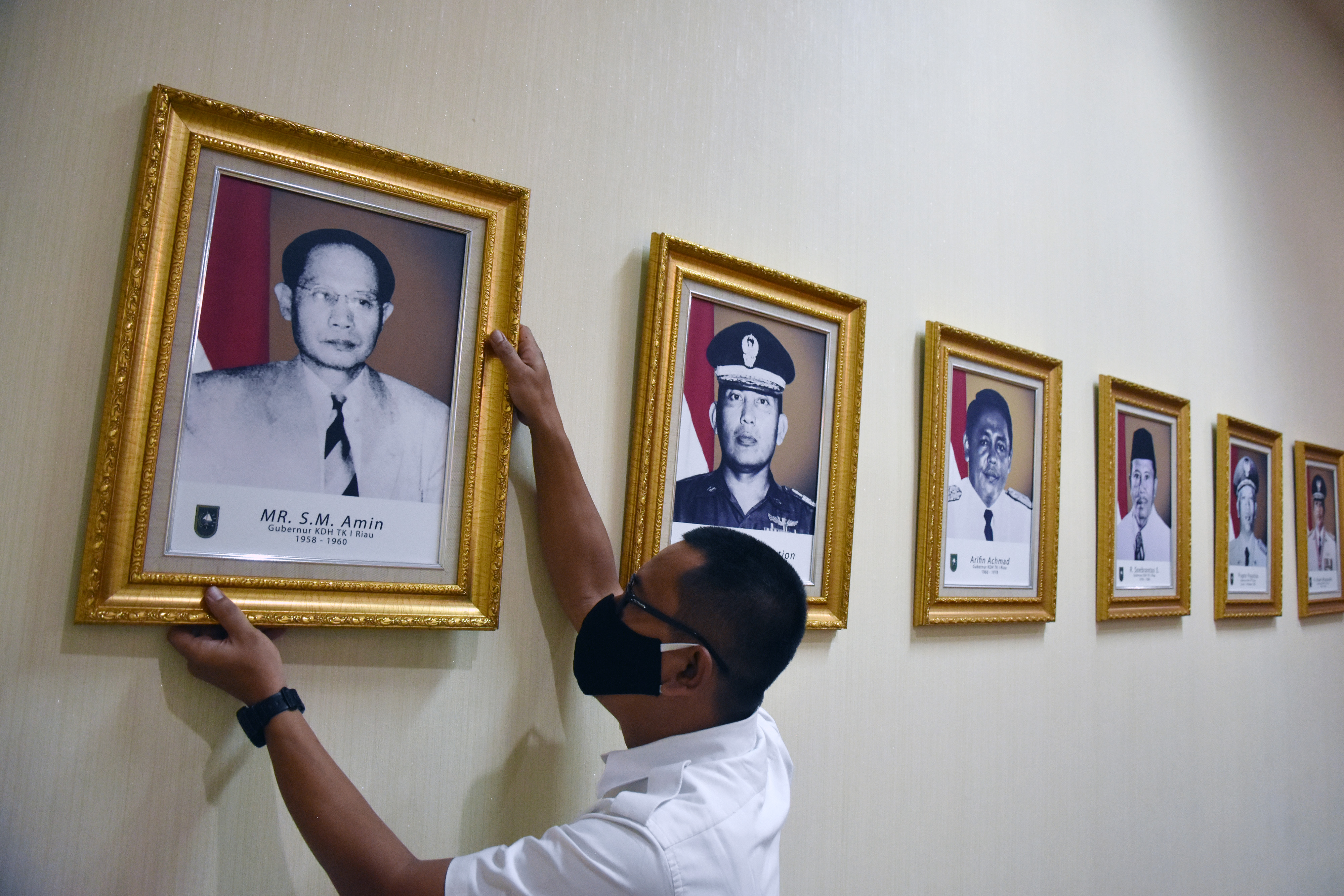 Seorang pegawai merapikan letak foto Gubernur Sumut pertama dan pernah menjadi Gubernur Riau pertama, Sultan Mohammad (SM) Amin Nasution. 