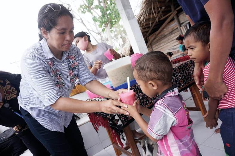 Ibu Anastasia Dego memberikan makanan tambahan berupa bubur kacang hijau kepada anak-anak di Posyandu Lenupetu, Rote Ndao, NTT.
