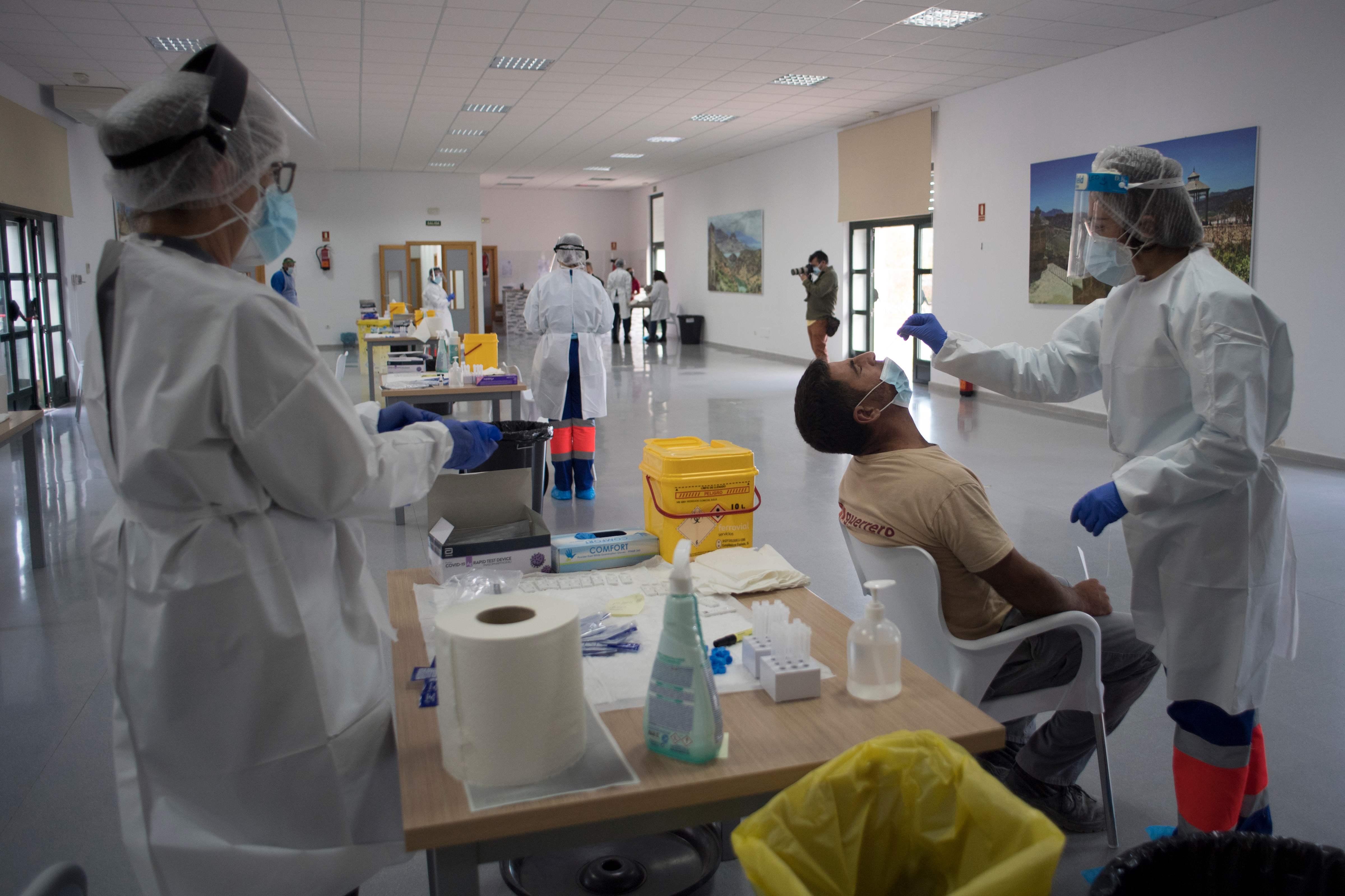 Petugas melalukan swab test terhadap warga di Ronda, Spanyol.