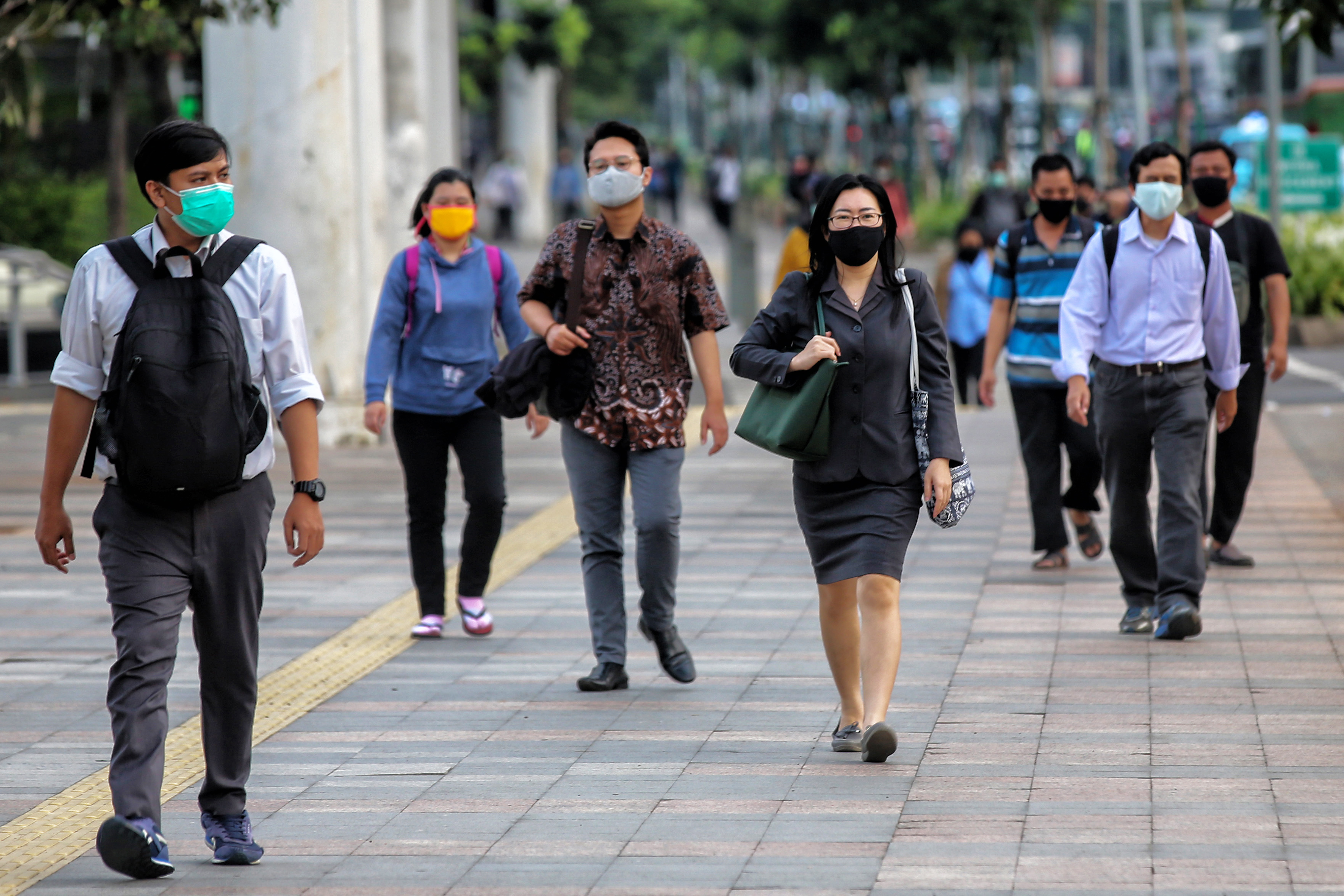 Pekerja di Jakarta mengenakan masker saat beraktivitas