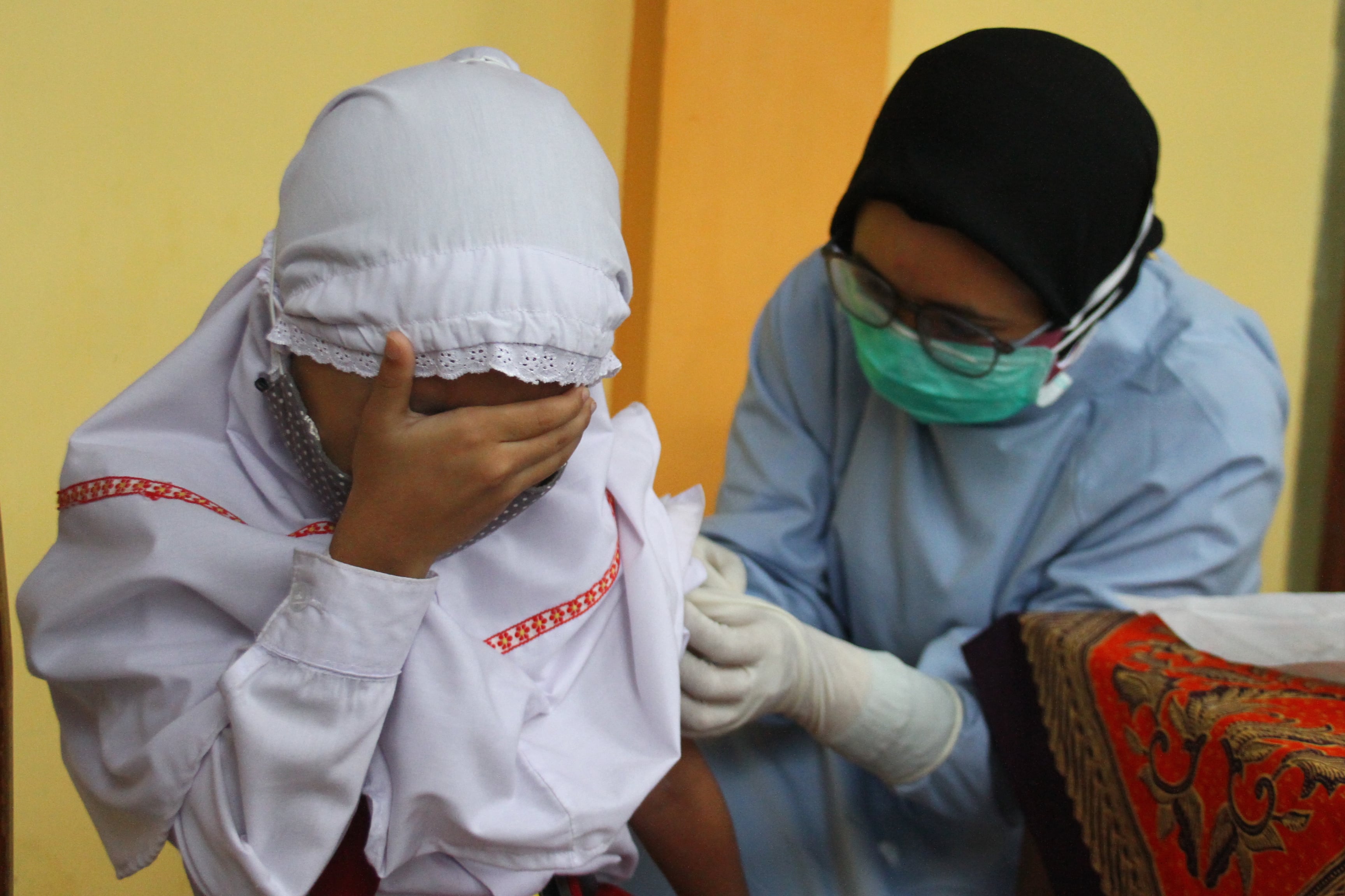 Petugas menyuntikkan vaksin TD pada seorang anak saat Bulan Imunisasi Anak Sekolah (BIAS) di MIN 2 Bandung Rejosari, Malang, Rabu (25/11).