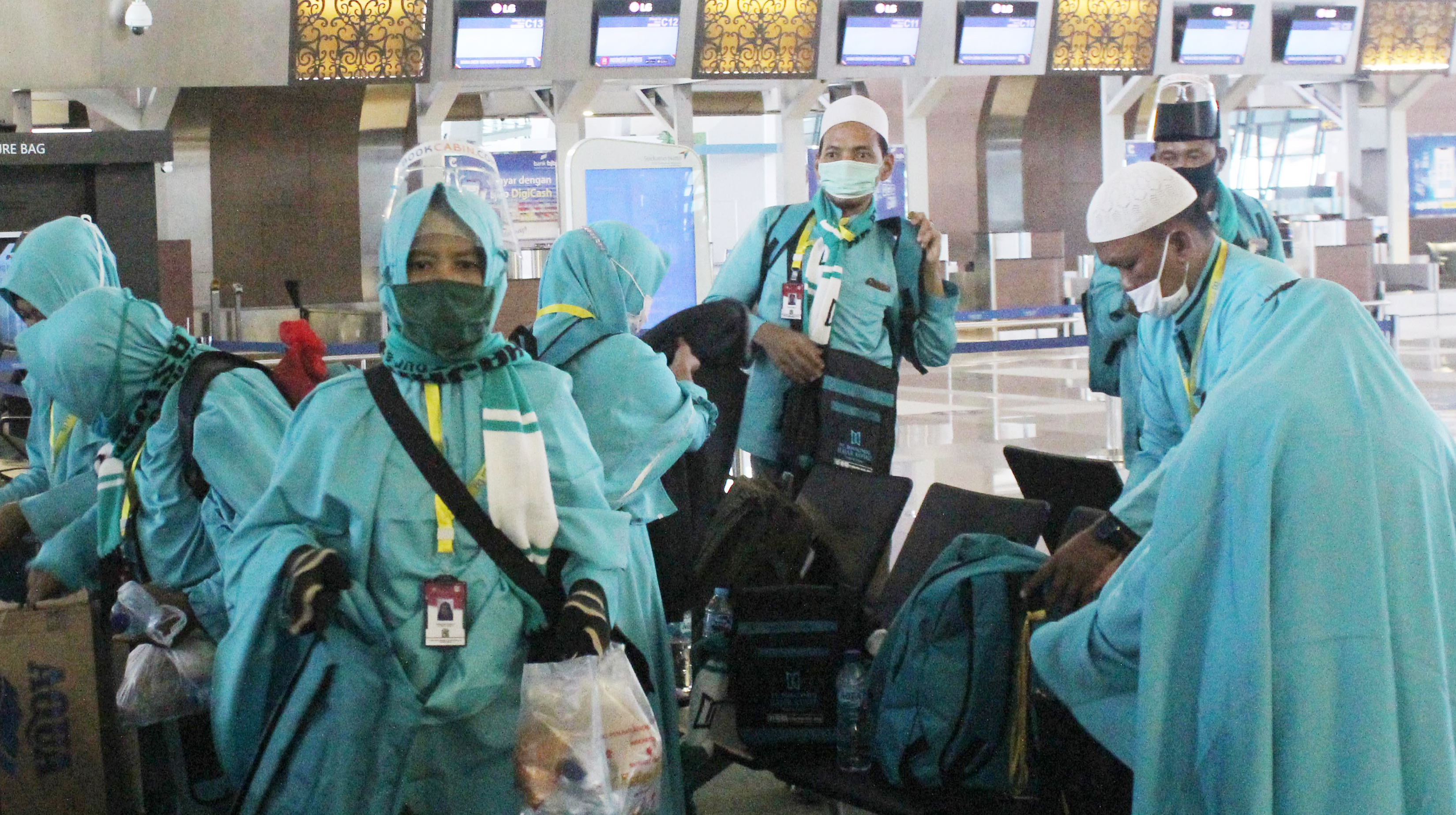 BERANGKAT UMRAH SAAT PANDEMI: Calon jemaah umrah bersiap berangkat dari Terminal 3 Bandara Soekarno-Hatta, Tangerang, Banten, kemarin.