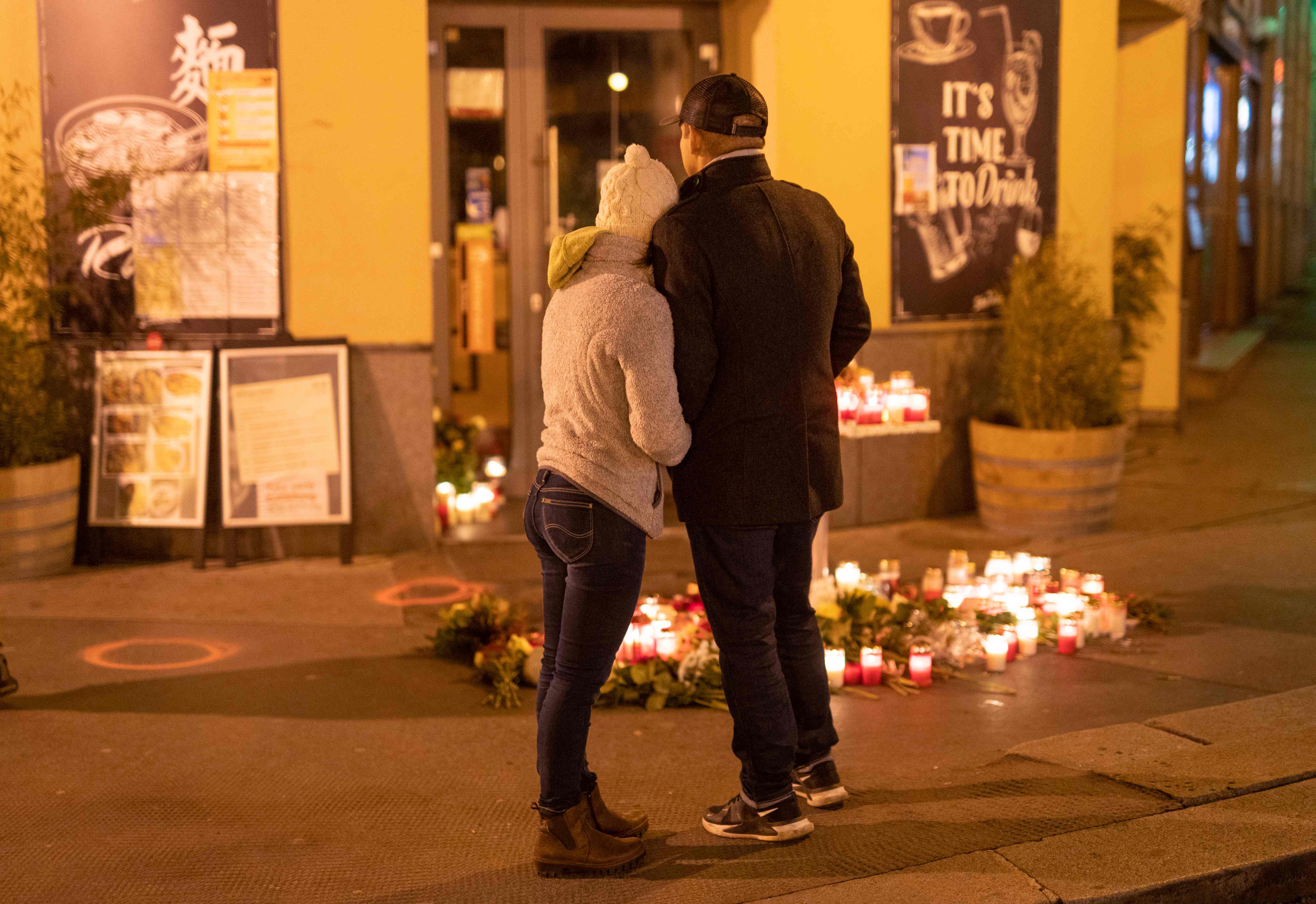 Sepasang laki-laki dan perempuan berdiri di depan restoran tempat insiden penembakan di Wina, Austria.