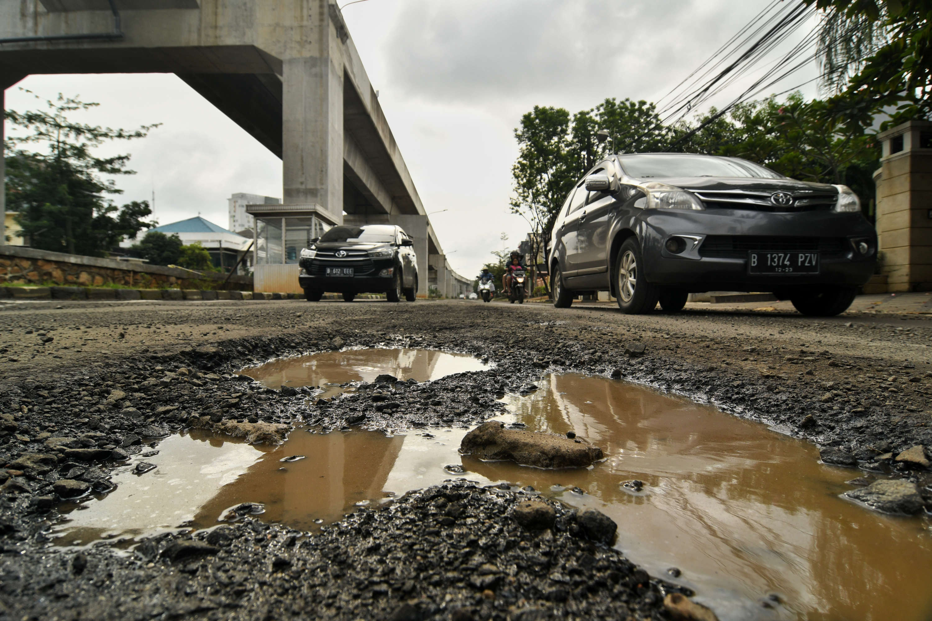 Sejumlah kendaraan memperlambat laju kendaraannya untuk menghindari lubang di kawasan Kelapa Gading, Jakarta Utara.