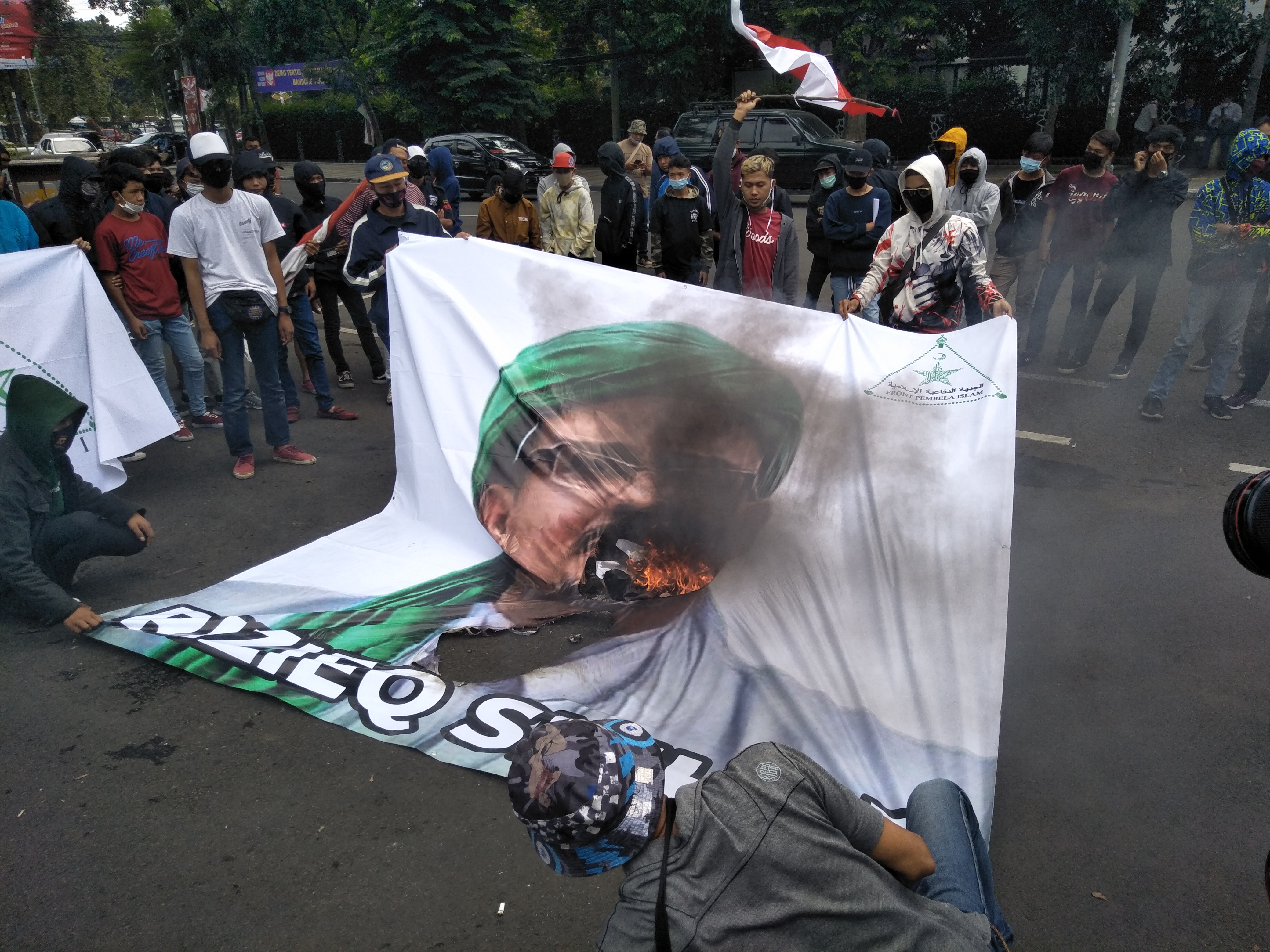Pengunjuk rasa membawa poster dan membakar foto rizieq shihab didepan kantor dprd jawa barat, bandung senin (23/11): 