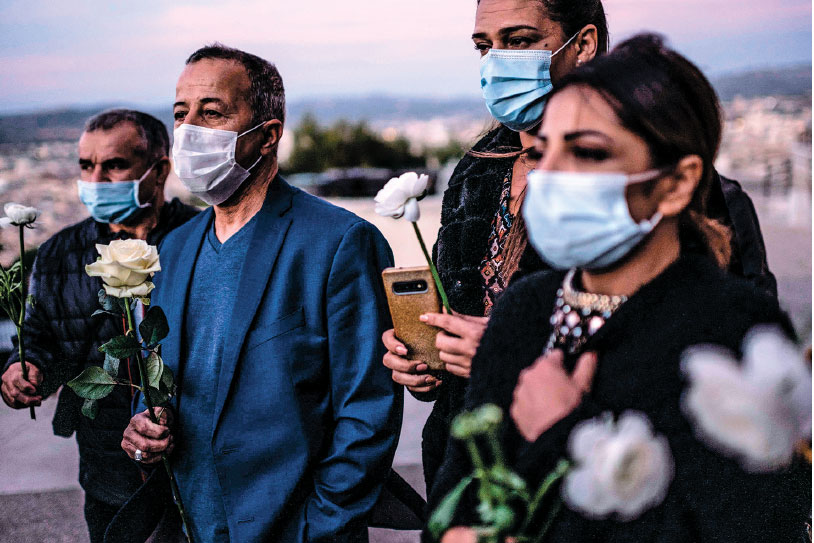 Umat muslim memegang bunga putih untuk memberikan penghormatan kepada para korban serangan pisau di Gereja Basilika Notre-Dame de la Garde 