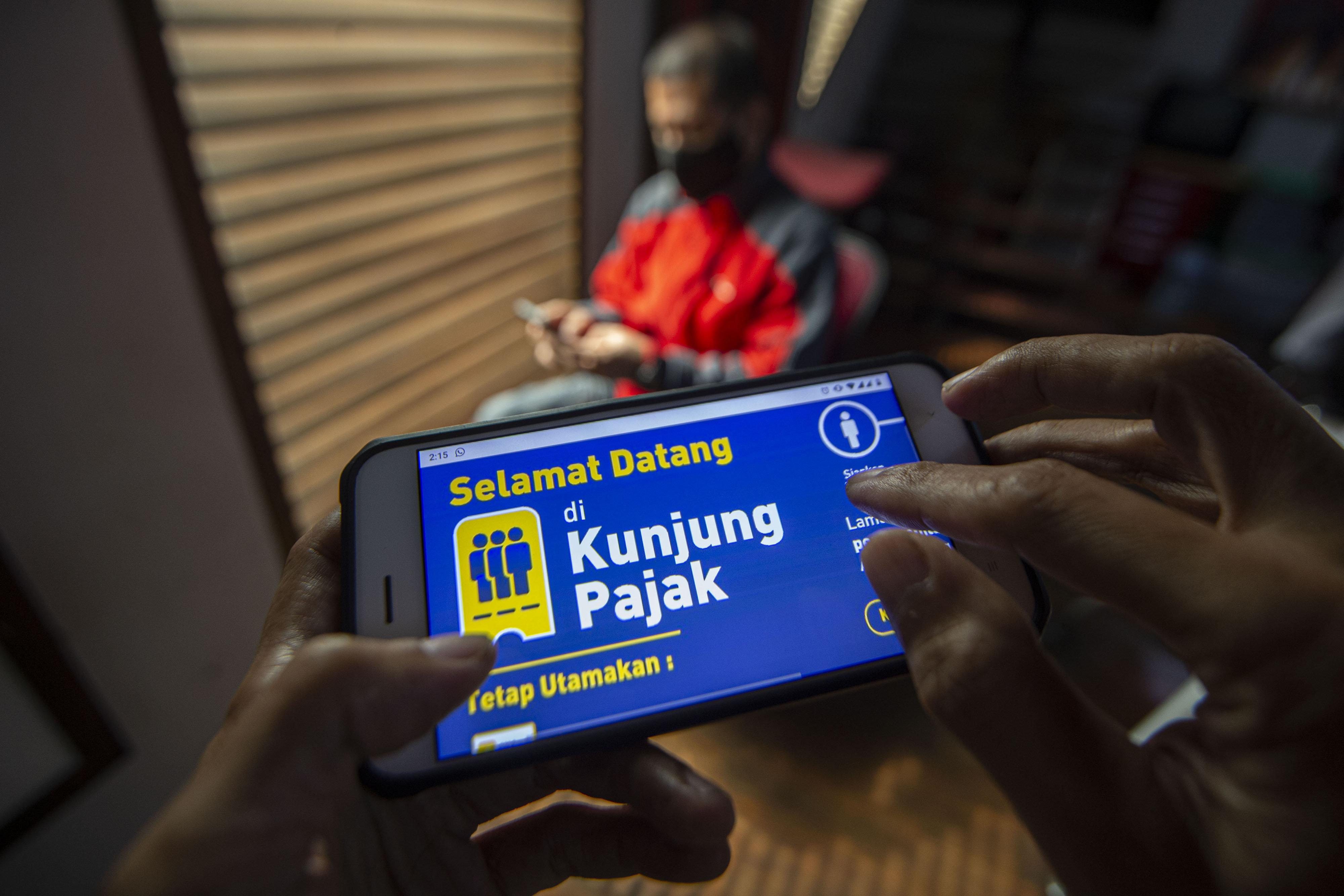 Warga mencari informasi tentang pajak di portal www.pajak.go.id dengan telepon pintarnya di Jakarta, Selasa (24/11/2020