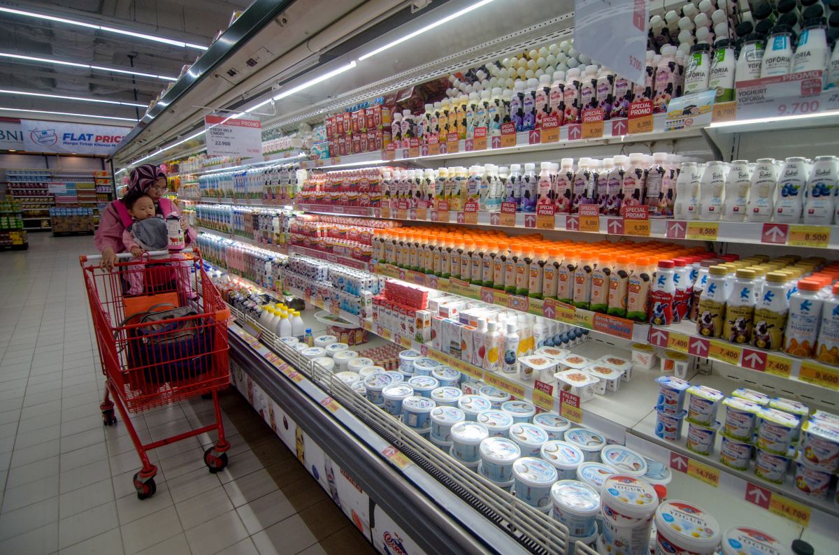 Konsumen memilih produk makanan dan minuman saat berbelanja di supermarket.