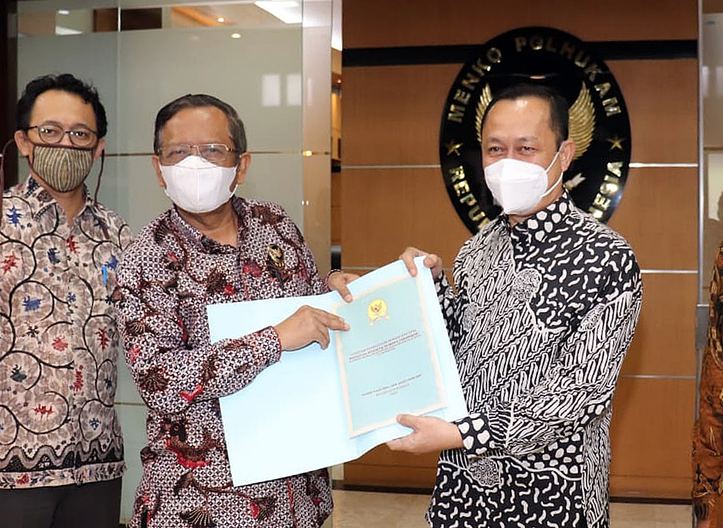 Mahfud MD (tengah) menerima hasil investigasi kasus kekerasan di Intan Jaya yang diserahkan Ketua Komnas HAM Ahmad Taufan Damanik.