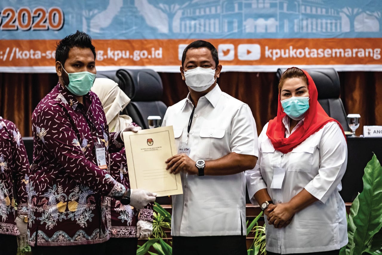 Ketua KPU Kota Semarang Henry Casandra Gultom (kiri) menyerahkan berkas surat keputusan tata letak posisi kertas suara.