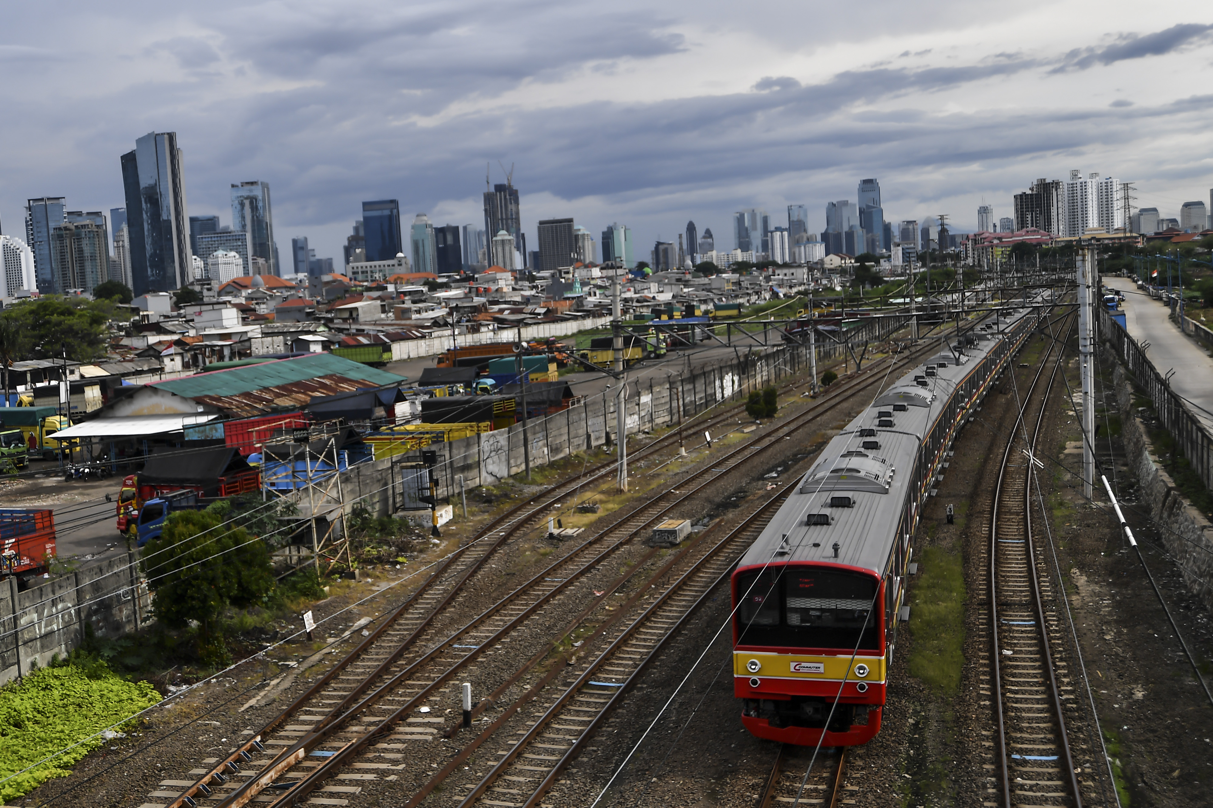 kereta melintas dengan latar belakang gedung bertingkat di Jakarta