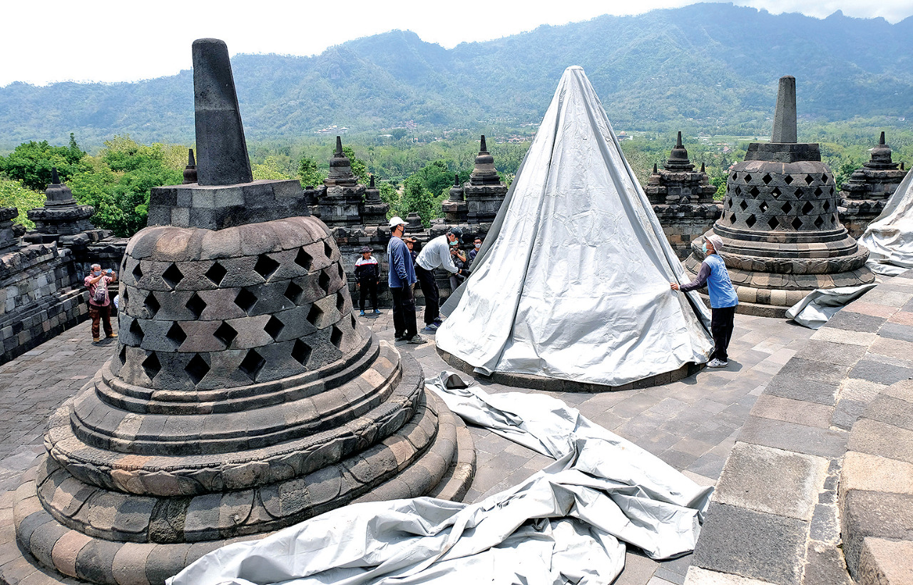 Pekerja menutup stupa menggunakan terpaulin di kompleks Candi Borobudur, Magelang, Jateng, kemarin.