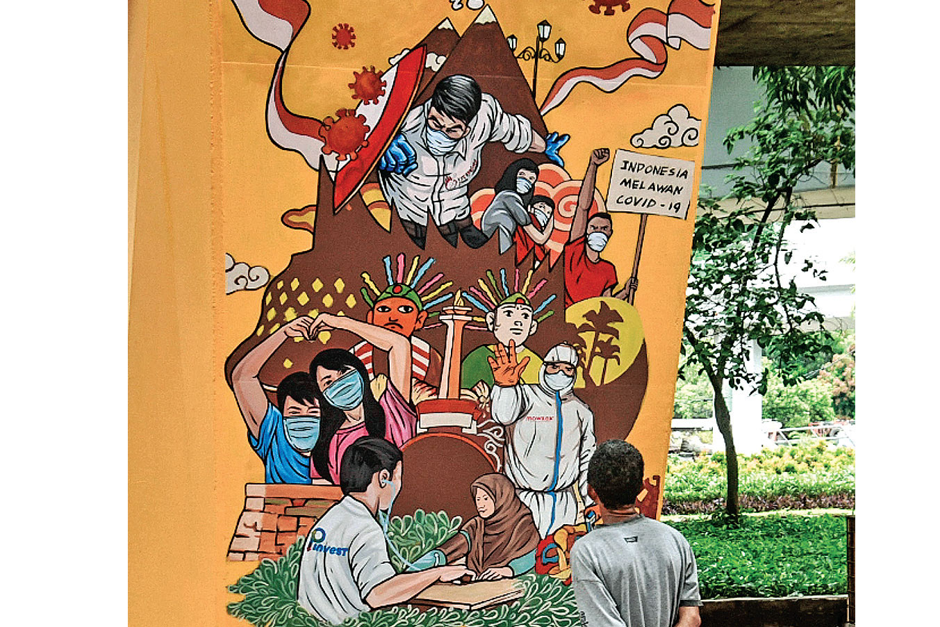 KAMPUNG TANGGUH COVID-19: Warga melihat mural bergambar pandemi covid-19 di dinding tiang jalan tol kawasan Tomang, Jakarta Barat, kemarin.