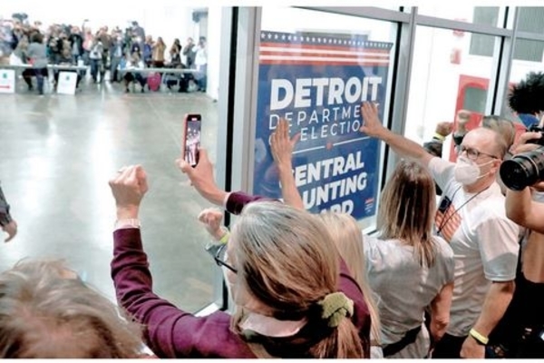 Pendukung calon presiden petahana dari Partai Republik, Donald Trump, menggedor kaca pembatas di Detroit, Michigan, AS, Rabu (4/11).