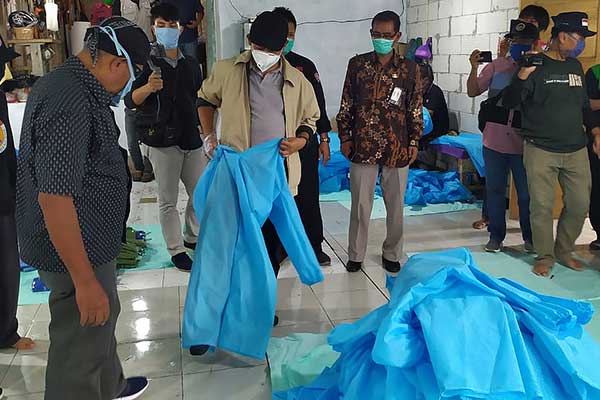 Bupati Banyumas Achmad Husein (tengah) mencoba baju hazmat di salah satu usaha konveksi di Desa Tlaga, Kecamatan Gumelar, Banyumas.