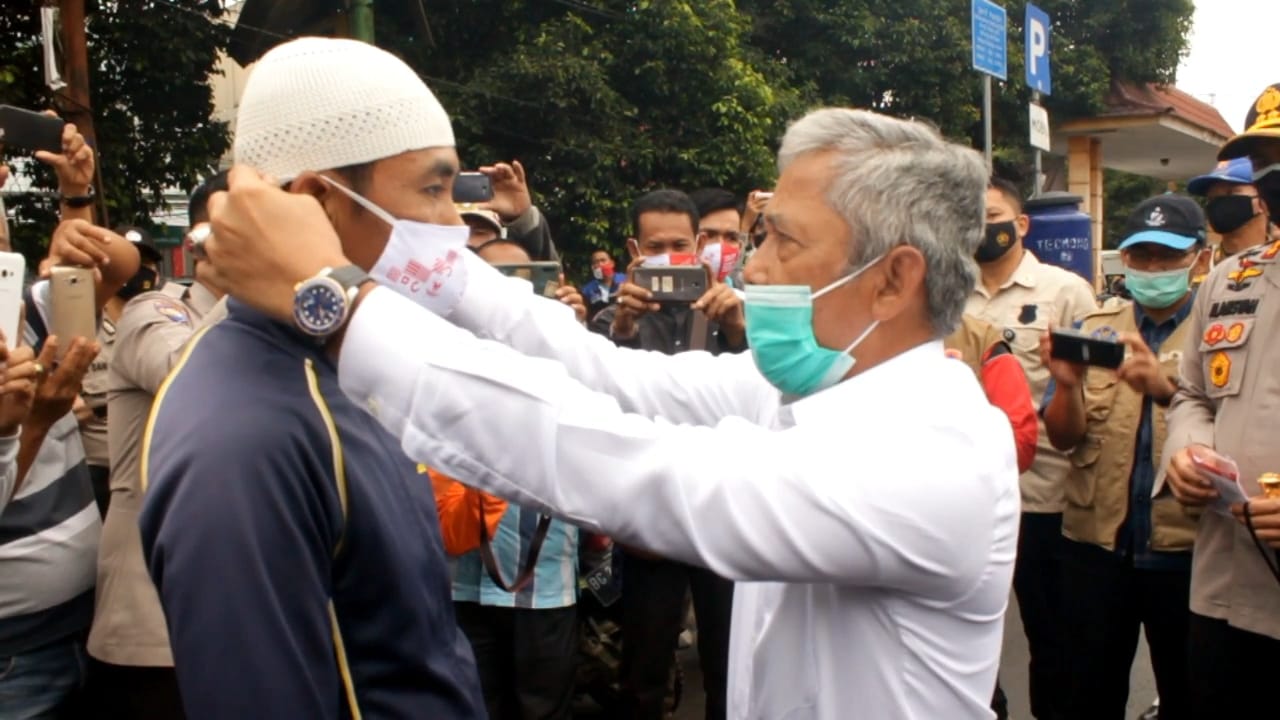 Bupati Ogan Komering Ilir, Iskandar memakaian masker kepada warganya yang ditemui di tempat keramaian, Senin (9/11/2020).