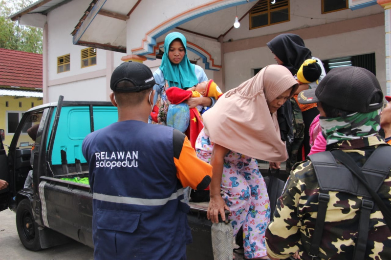 Relawan menurunkan para pengungsi Merapi di Tlogolele, Boyolali, Jawa Tengah