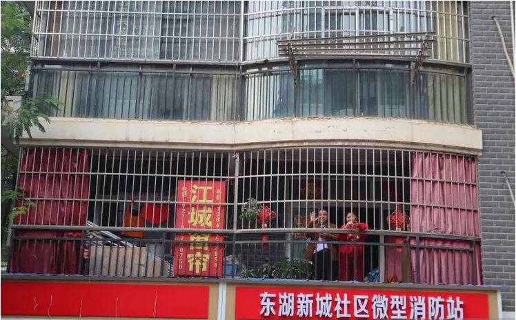 Warga kampung Donghu, Kota Wuhan, Provinsi Hubei, Tiongkok, melambaikan tangan. 