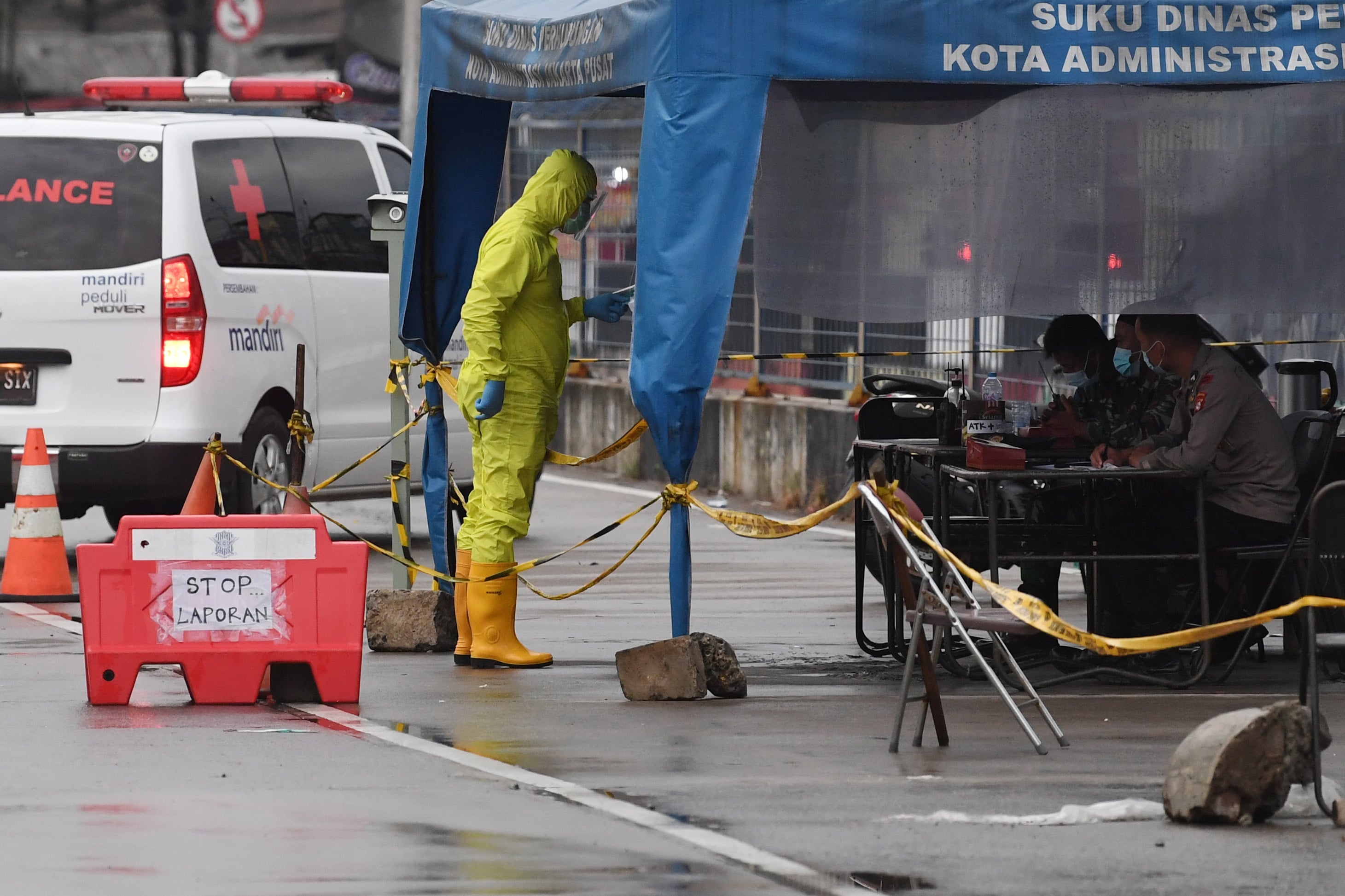 Seorang tenaga medis yang memakai hazmat melapor pada petugas saat mengantar pasien covid-19 di RSDC Wisma Atlet di Jakarta, Rabu (25/11).