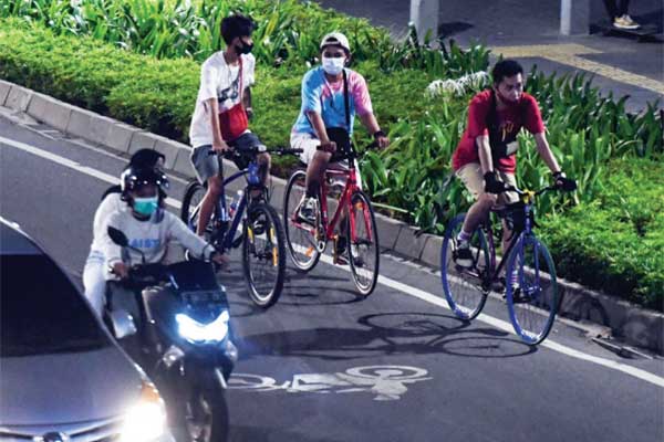 Pesepeda melintas pada malam hari di Jalan Sudirman, Jakarta