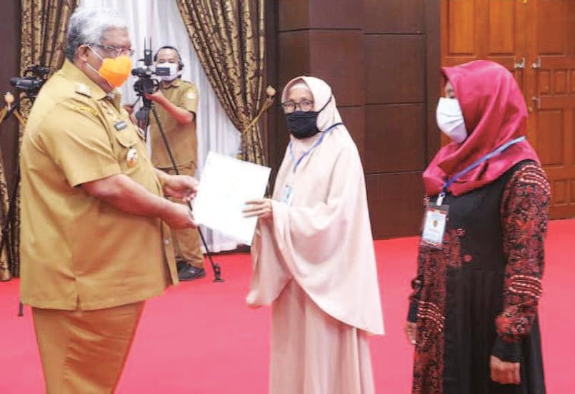 SERAHKAN SERTIFIKAT TANAH: Gubernur Sulawesi Tenggara Ali Mazi (kiri) menyerahkan secara simbolis sertifi kat tanah kepada perwakilan warga 