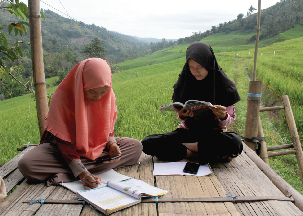 Sejumlah siswa SMA mengikuti kegiatan belajar mengajar dalam jaringan (daring) di area persawahan Bassaran, Desa Rante Mario.