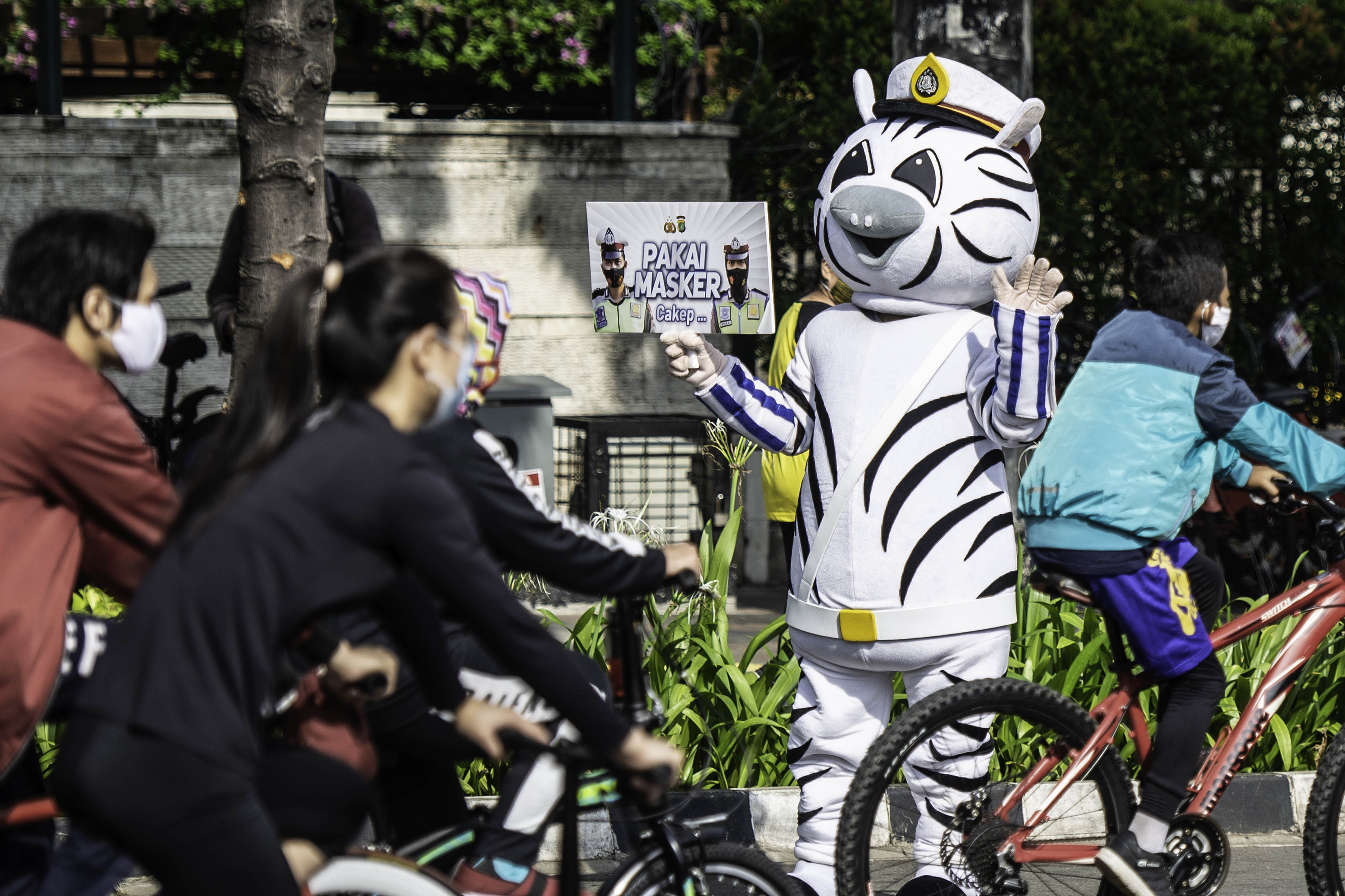 Petugas kepolisian melakukan sosialisasi protokol kesehatan di kawasan Bundaran HI, Jakarta.