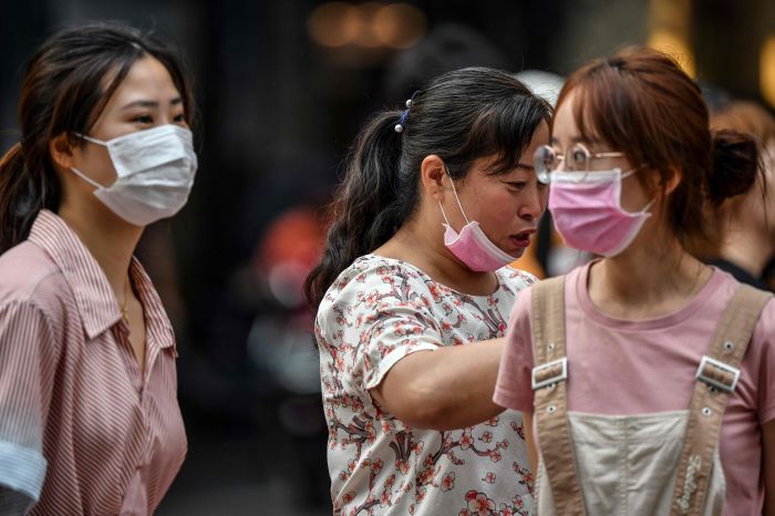 Warga mengenakan masker di Shanghai, Tiongkok.