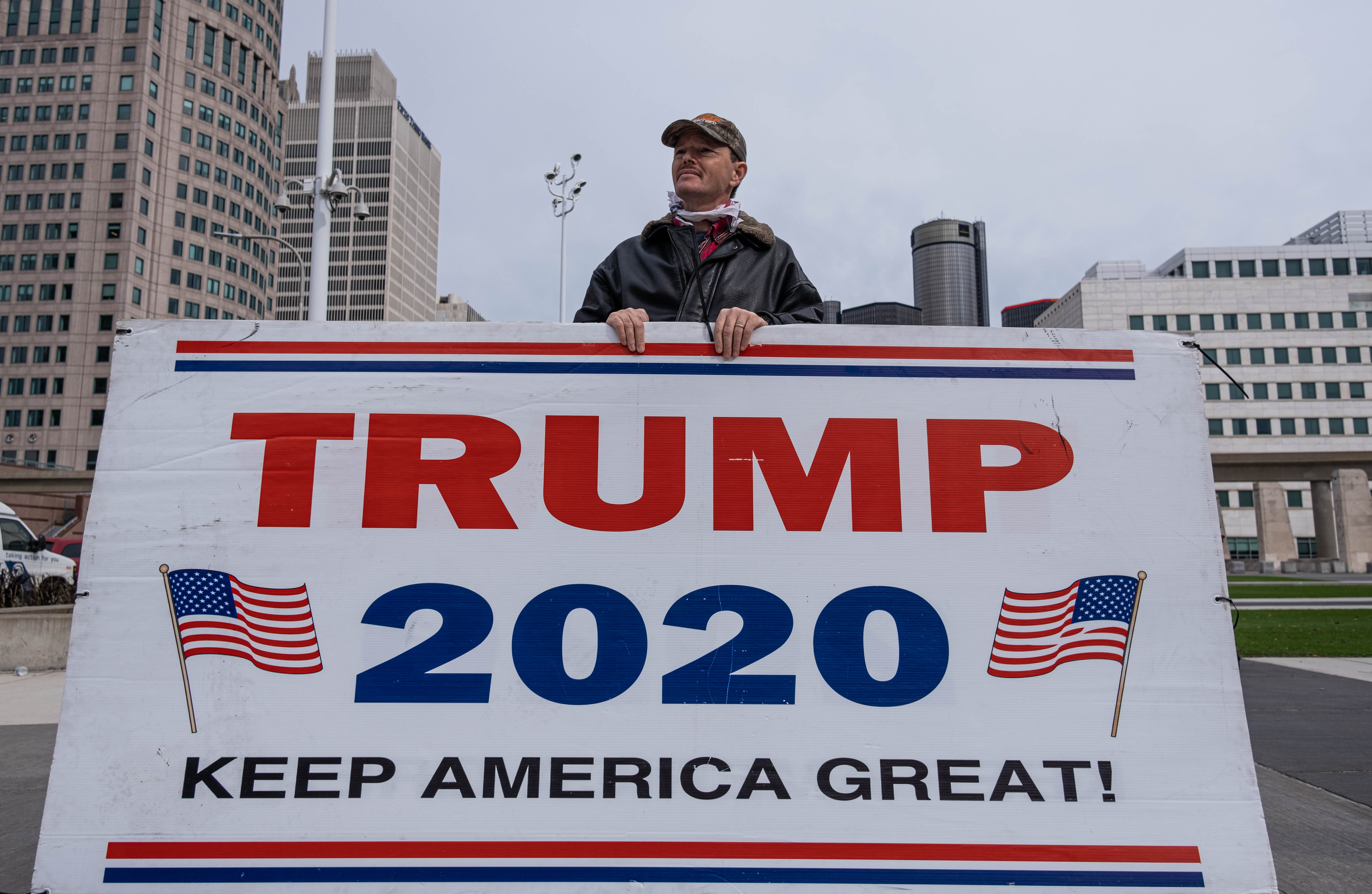 Seorang pendukung petahana Donald Trump melakukan aksi demonstrasi di Detroit, Michigan.