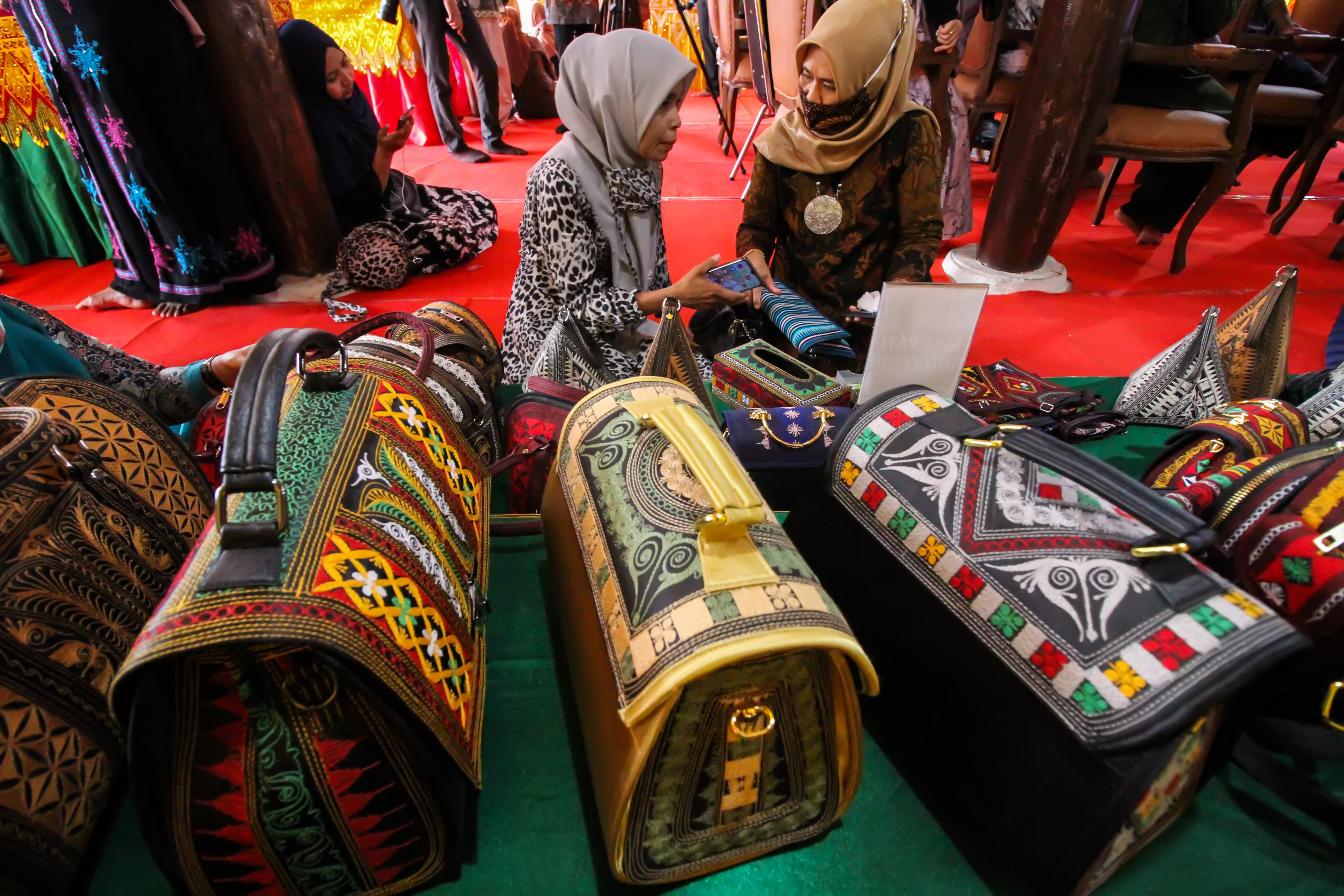Pelaku Usaha Mikro Kecil Menengah (UMKM) menata tas motif Aceh pada Pameran UMKM Kreatif Bank Indonesia (BI) di komplek Museum Lhokseumawe.